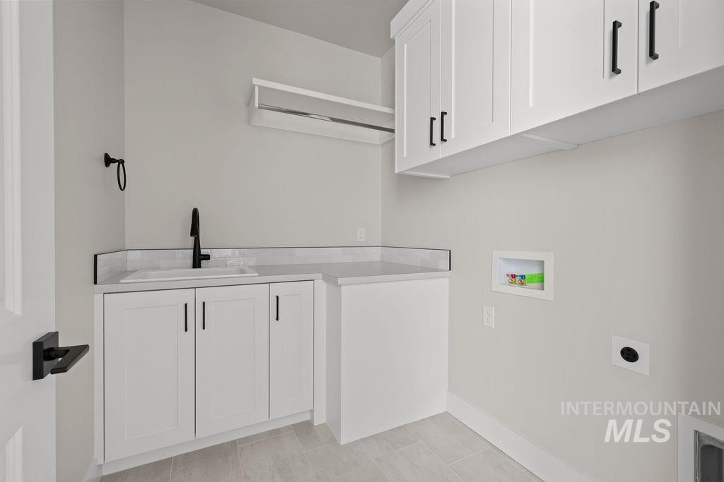 Laundry room featuring cabinet space, hookup for a washing machine, and electric dryer hookup