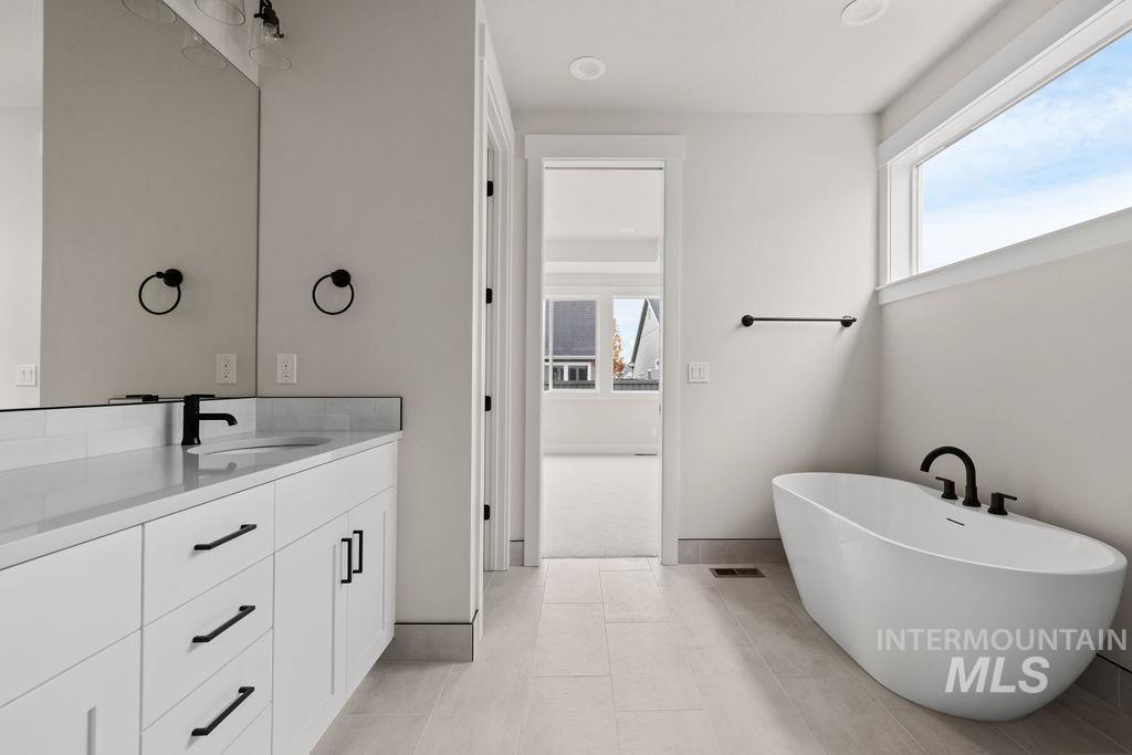 Bathroom with a freestanding tub, healthy amount of natural light, and vanity