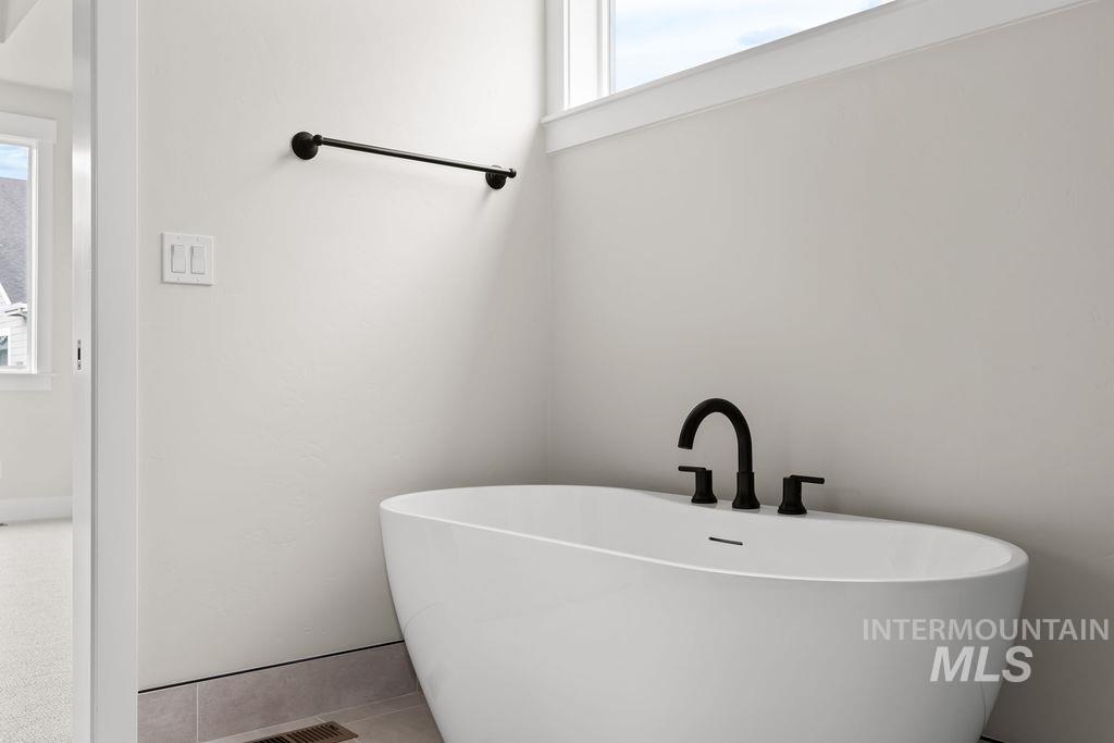 Full bathroom featuring healthy amount of natural light and a freestanding bath