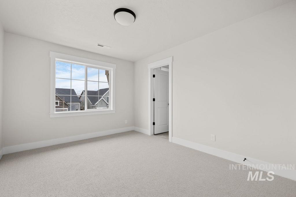 Carpeted spare room with baseboards