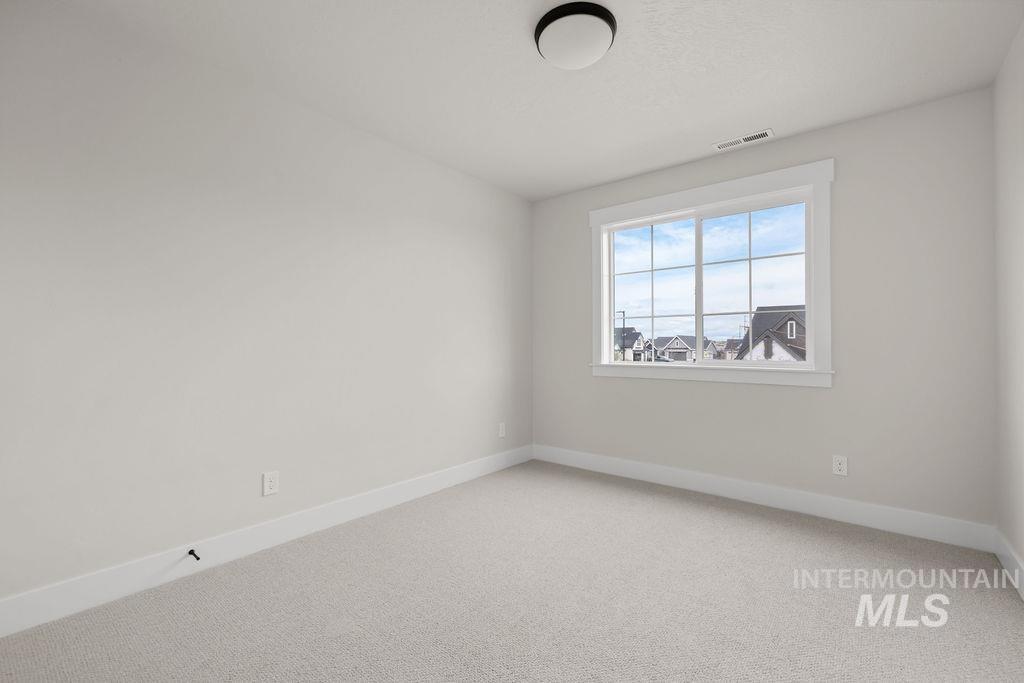 Spare room featuring baseboards and light carpet