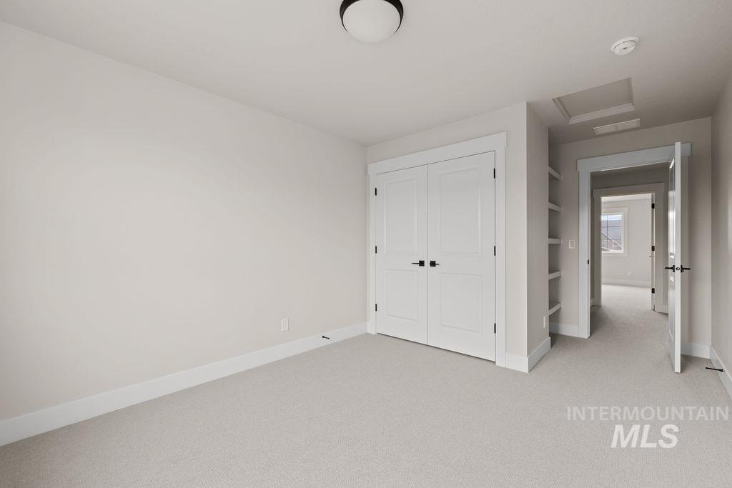Unfurnished bedroom featuring light carpet and a closet