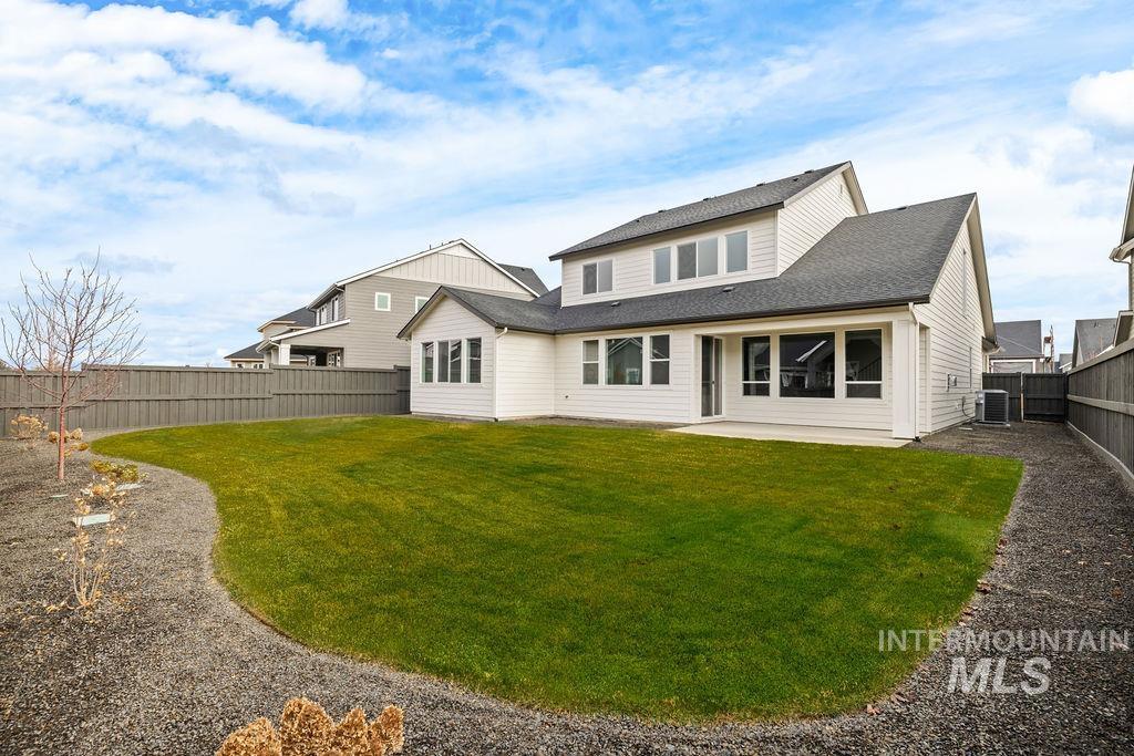 Back of house with a patio area, a fenced backyard, and roof with shingles