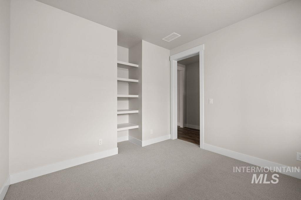Spare room with built in features and light carpet