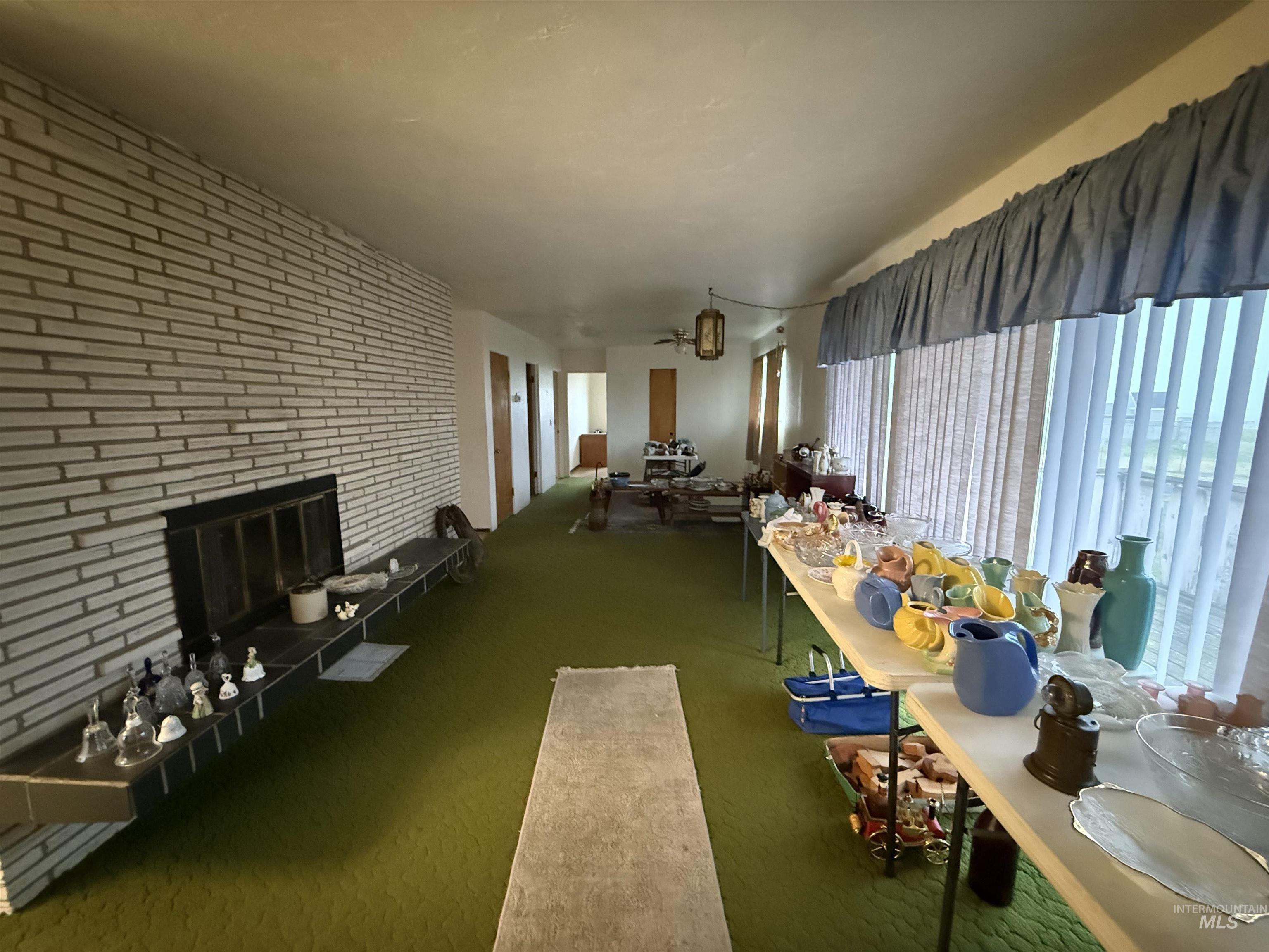 Carpeted dining space featuring a brick fireplace