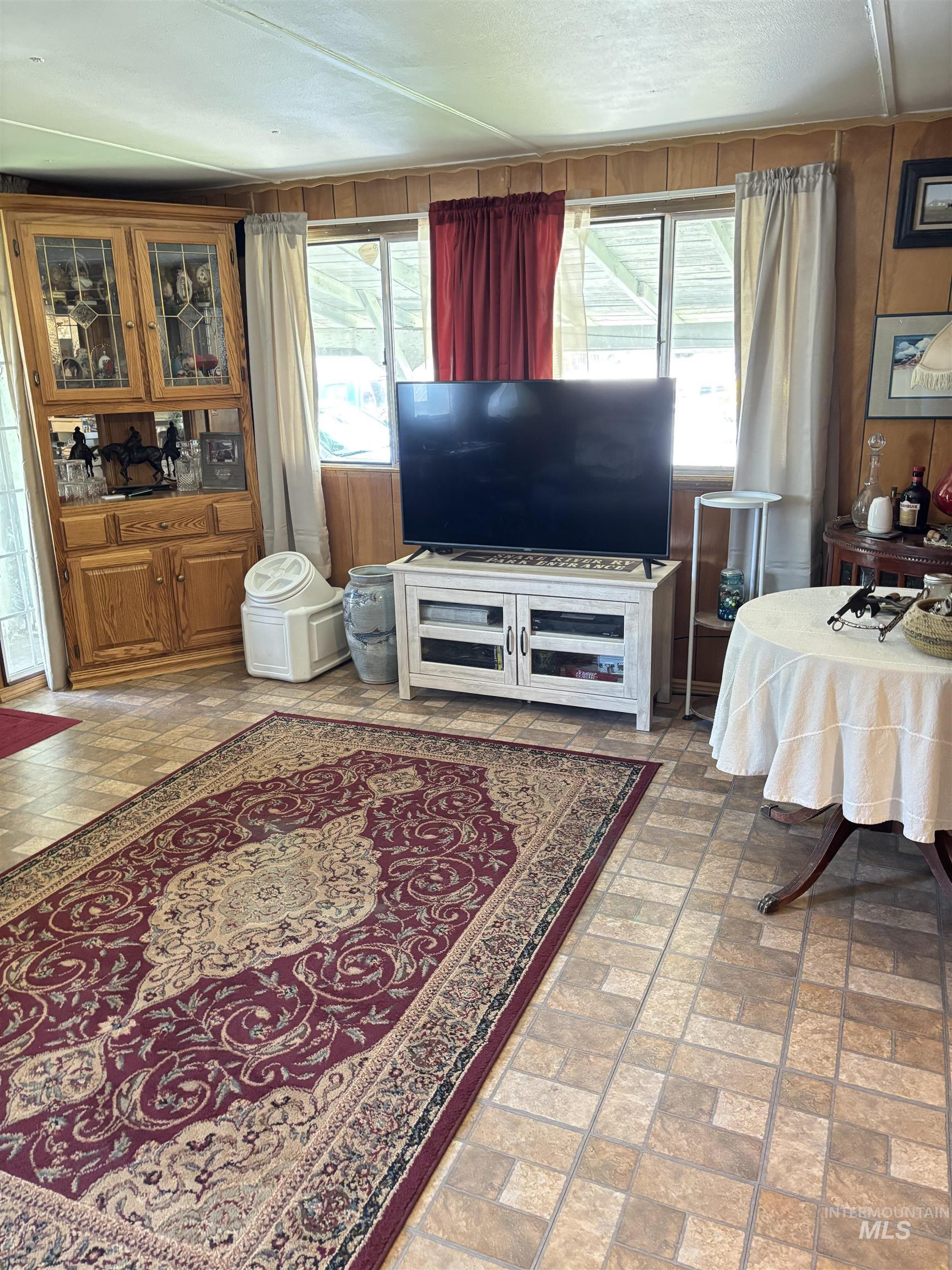 Living area with brick patterned flooring and wooden walls