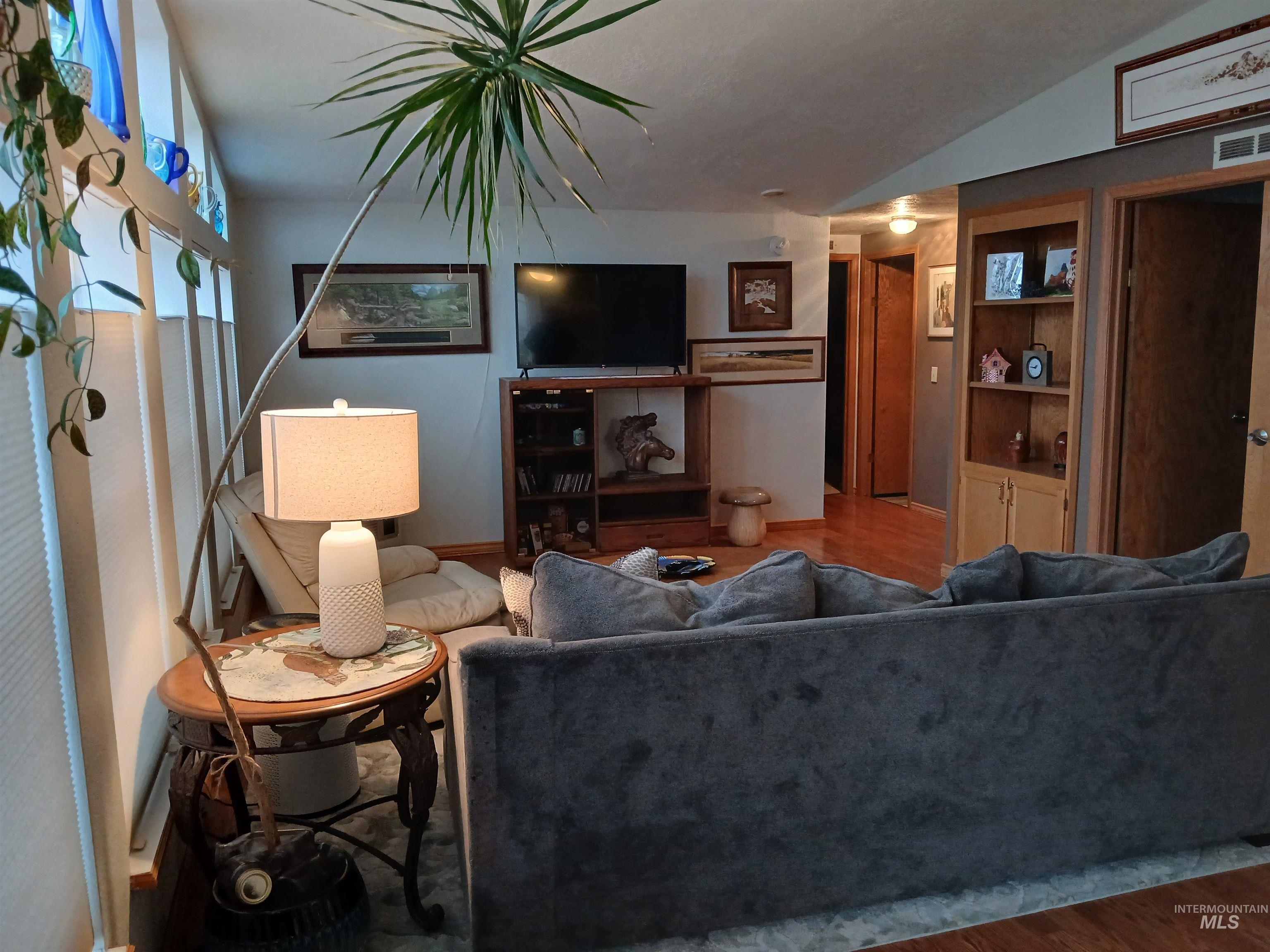 Living area featuring wood finished floors and lofted ceiling