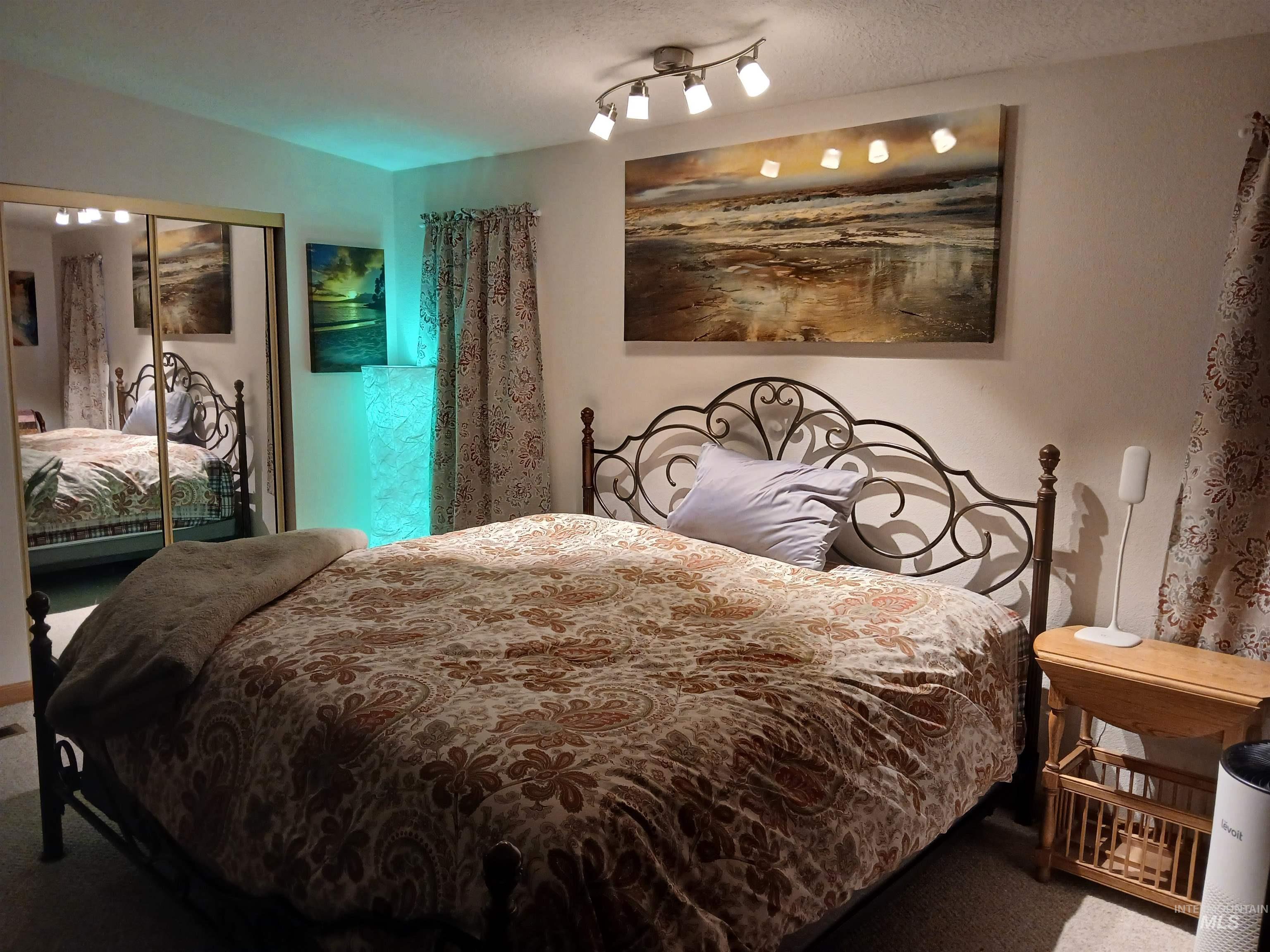 Bedroom with a closet, a textured ceiling, and carpet flooring