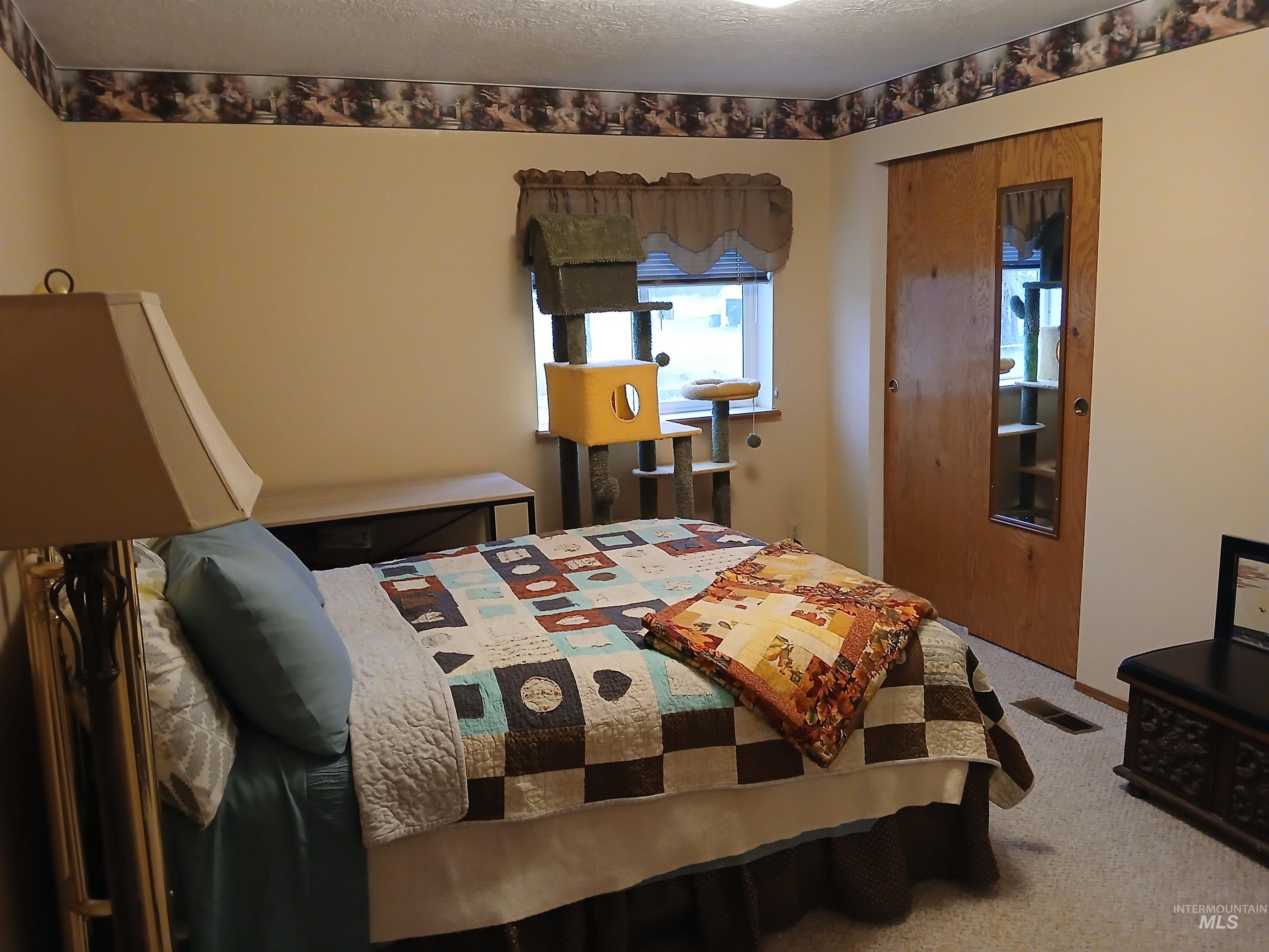 Bedroom featuring carpet, a closet, and a textured ceiling