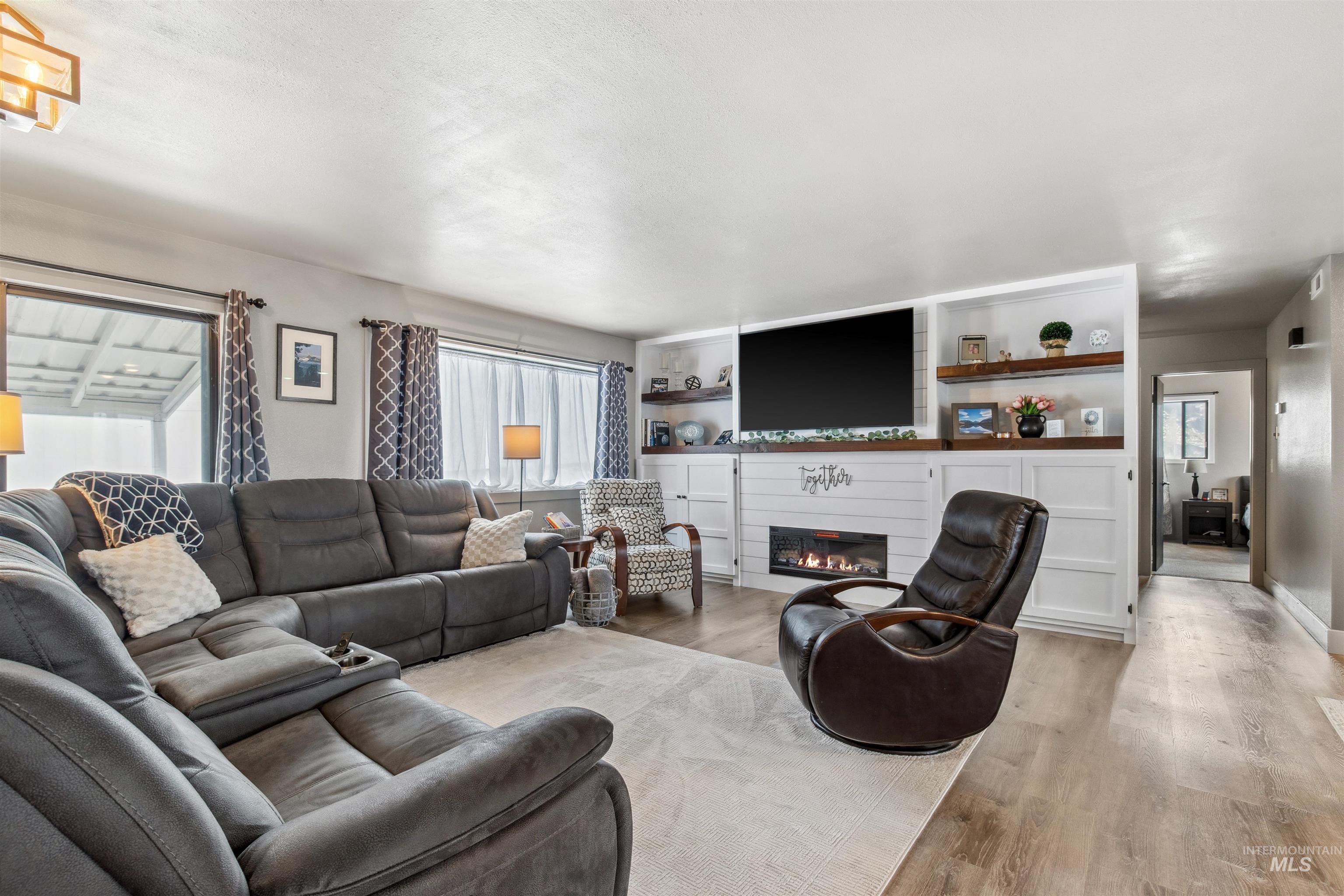 Living room featuring a large fireplace and wood finished floors