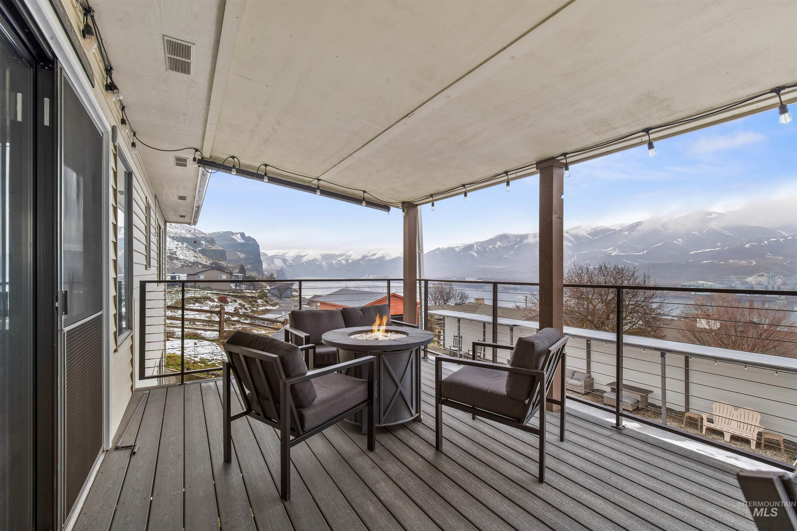 Deck featuring a mountain view, an outdoor fire pit, and a patio