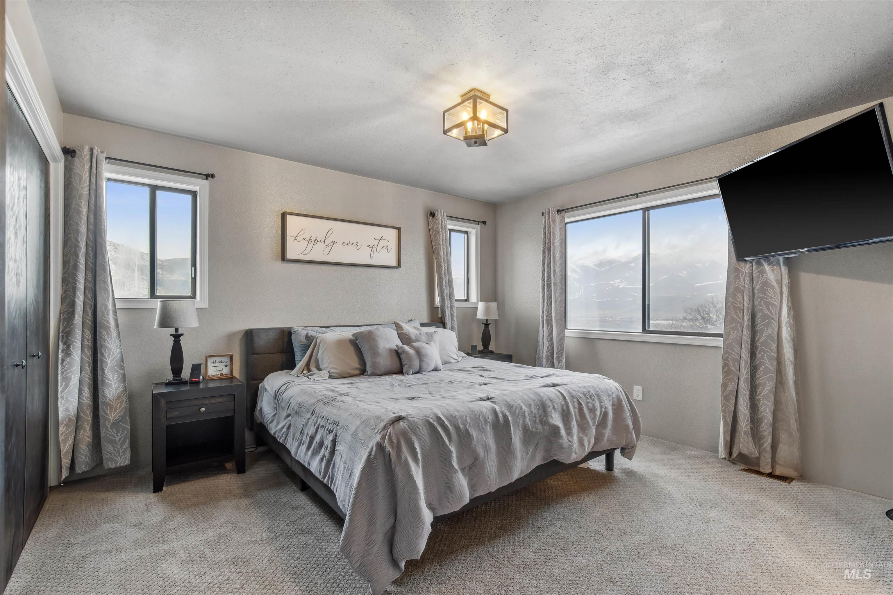 Bedroom featuring multiple windows and carpet floors