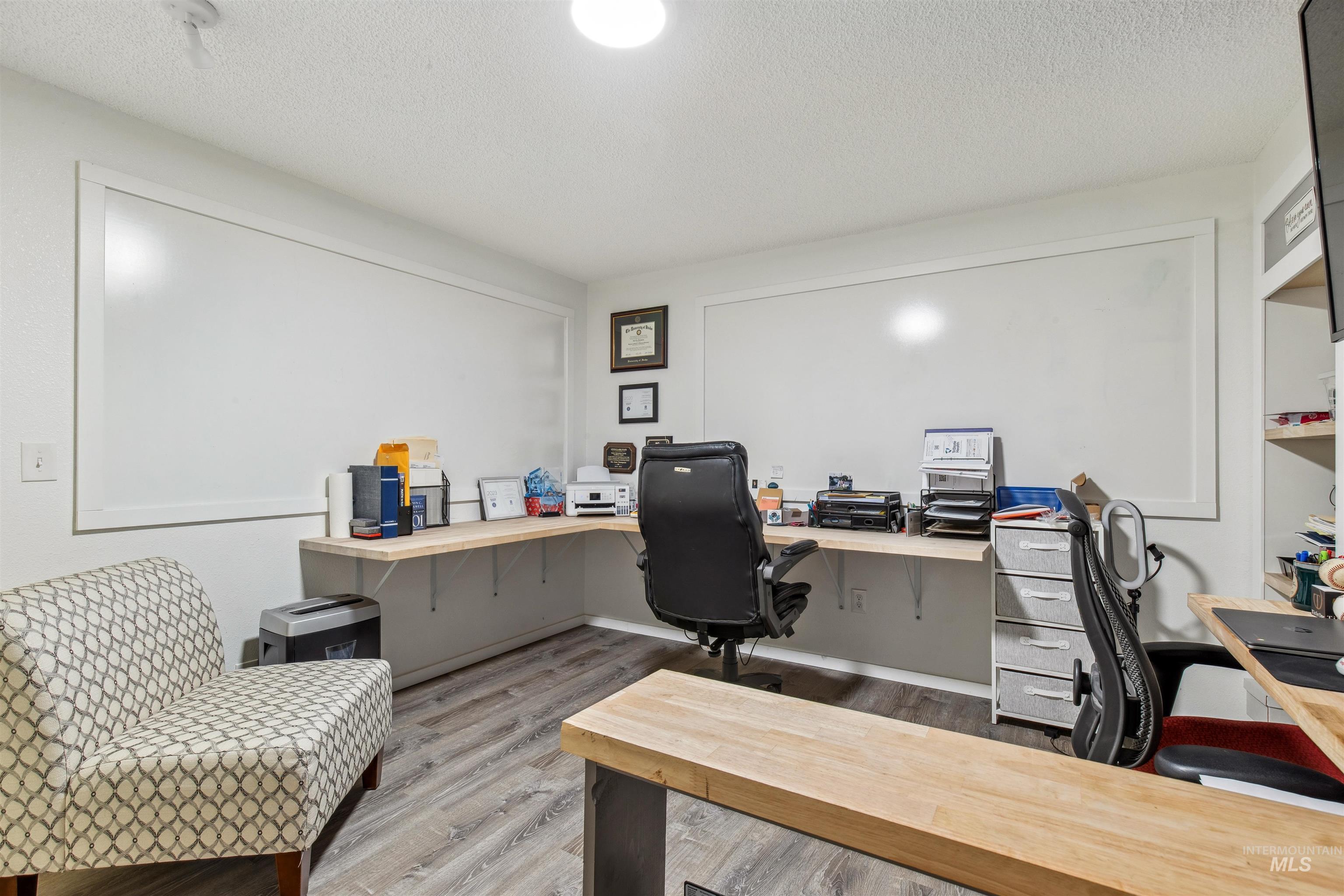 Office with a textured ceiling and light wood-style flooring
