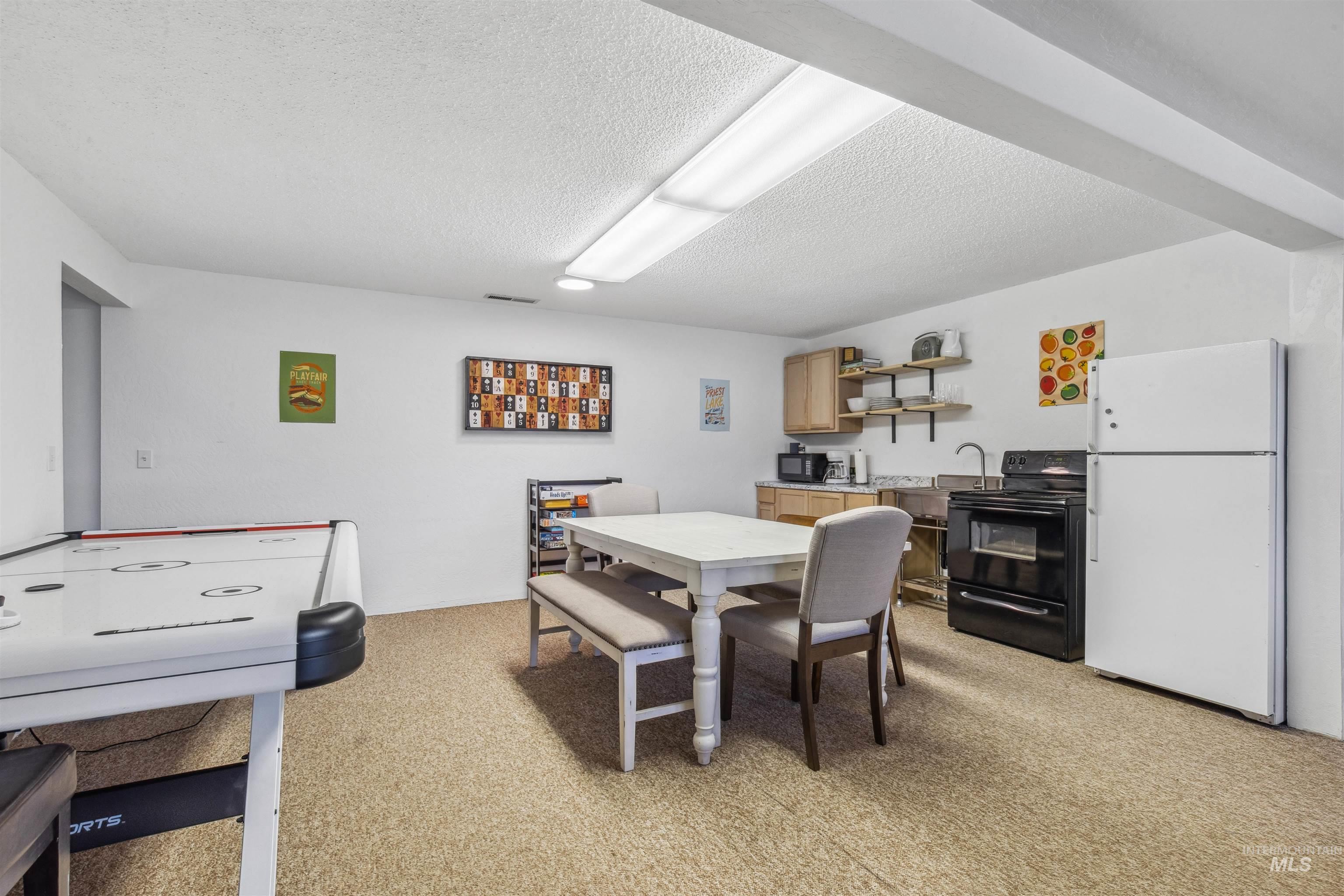 Dining space with a textured ceiling and light carpet