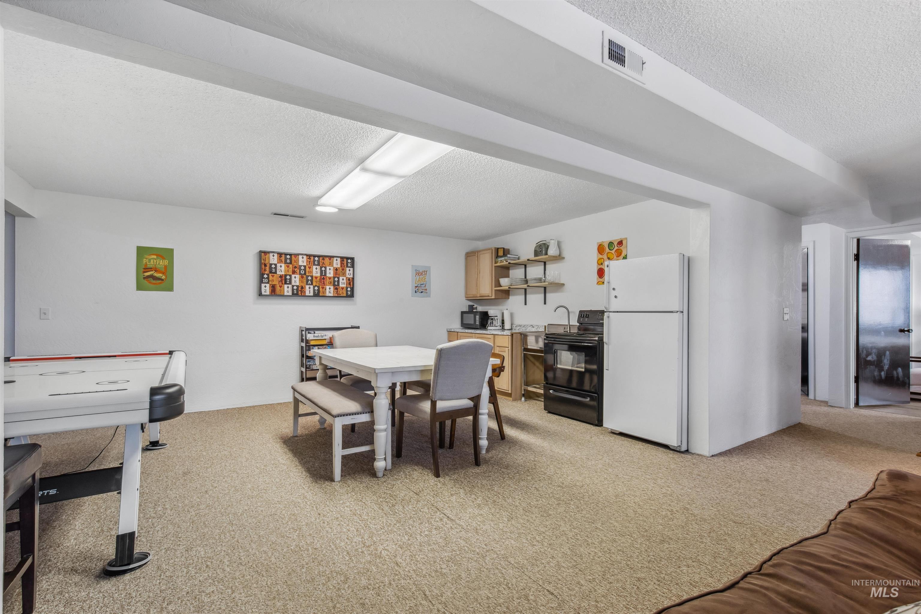 Dining area featuring a textured ceiling and light colored carpet