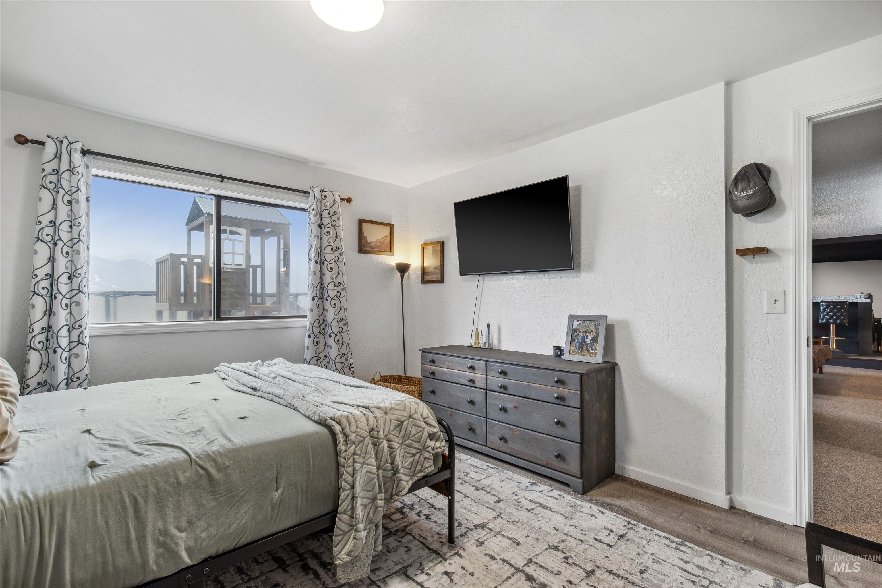 Bedroom with wood finished floors and baseboards
