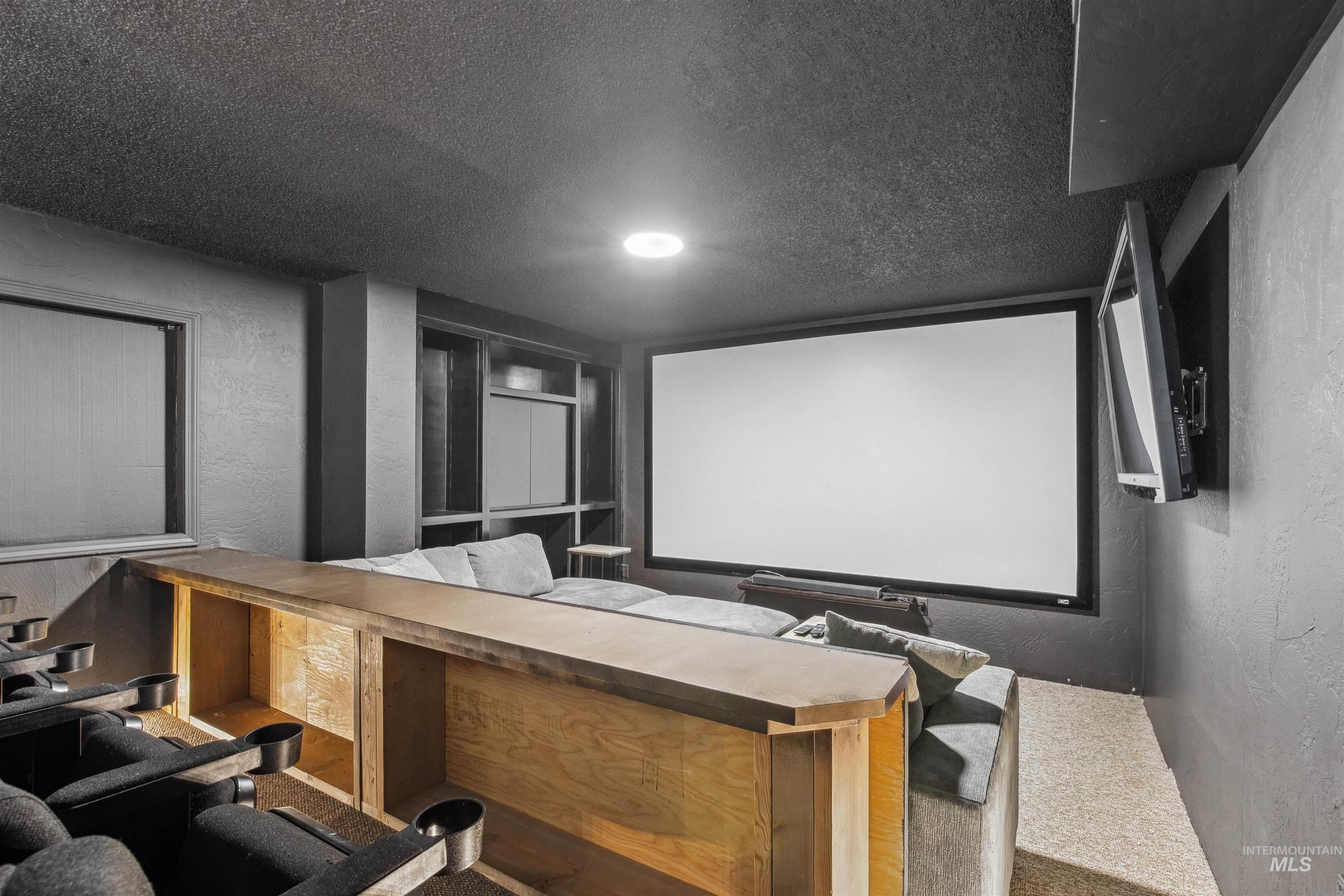 Home theater with a textured wall and a textured ceiling