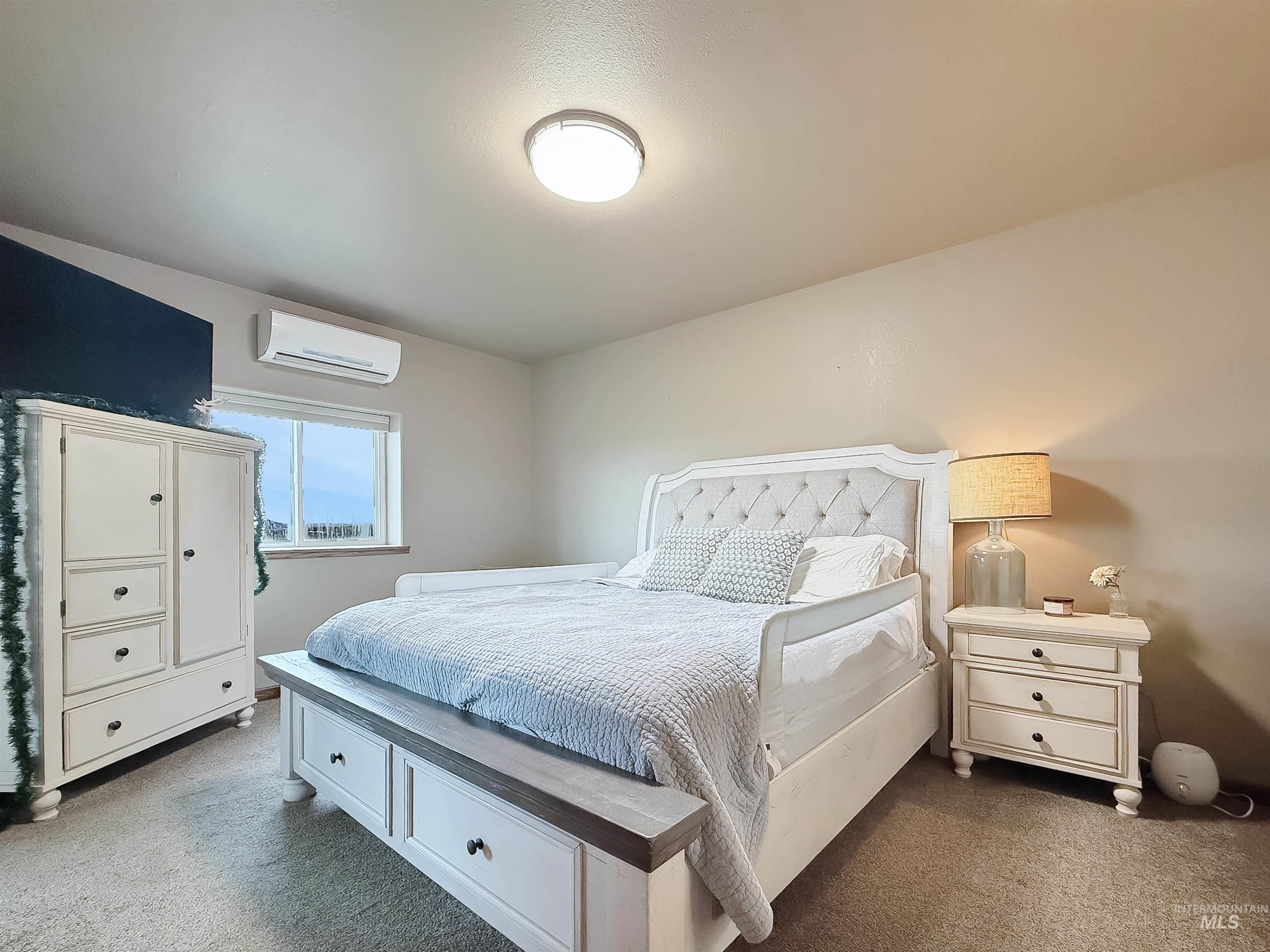 Carpeted bedroom with an AC wall unit