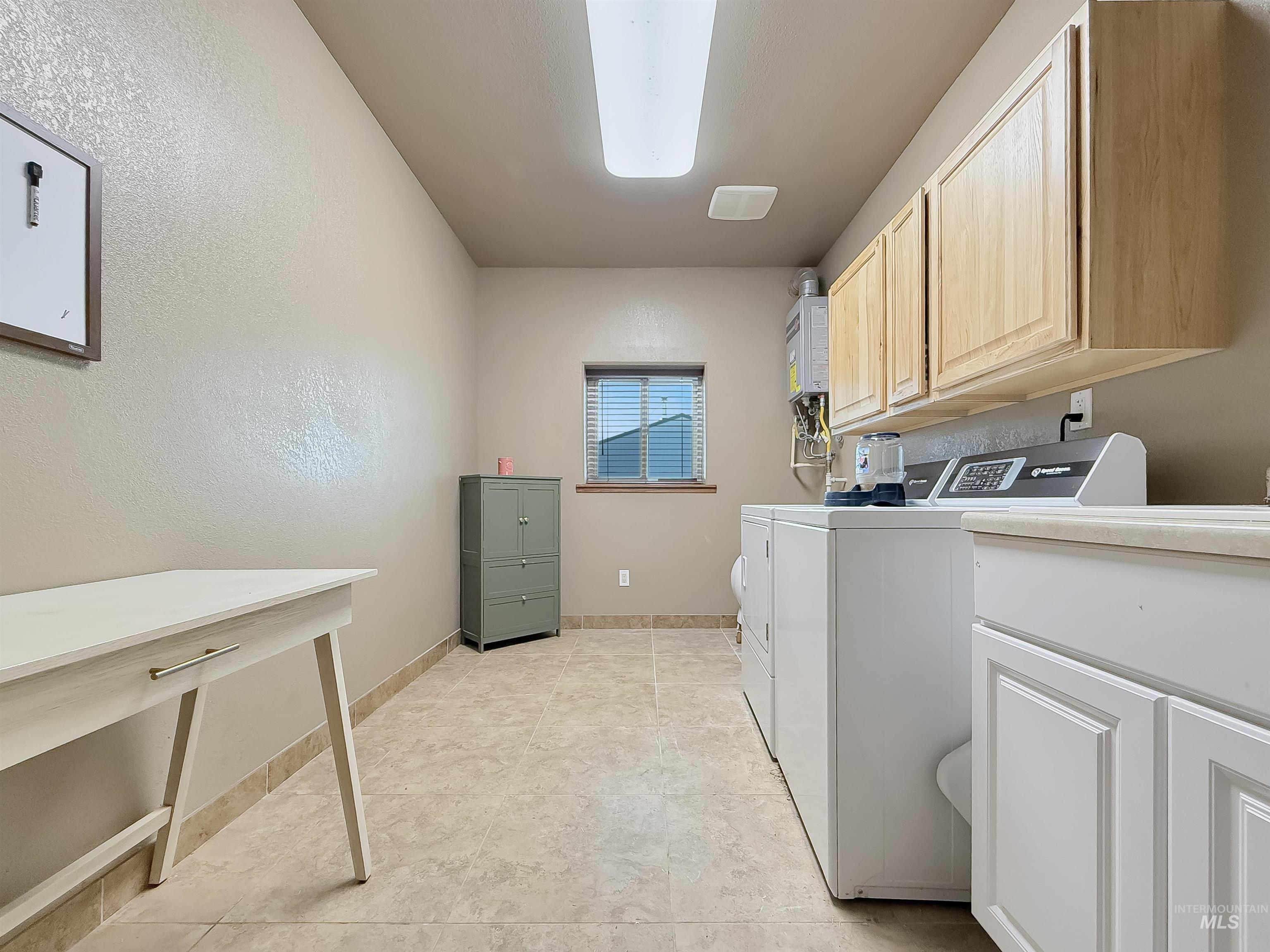 Washroom featuring washing machine and clothes dryer and baseboards