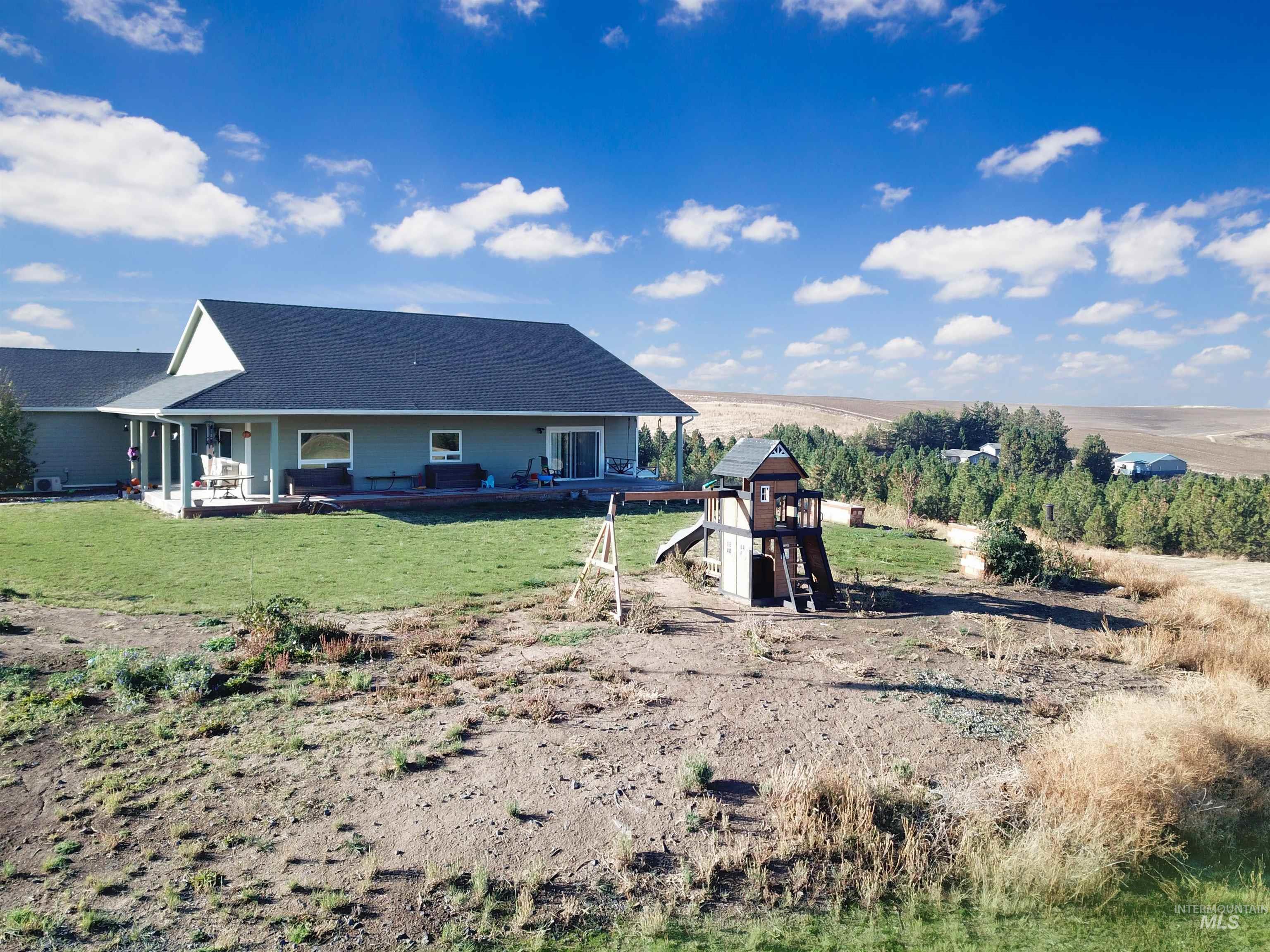 Rear view of house with roof with shingles and a yard
