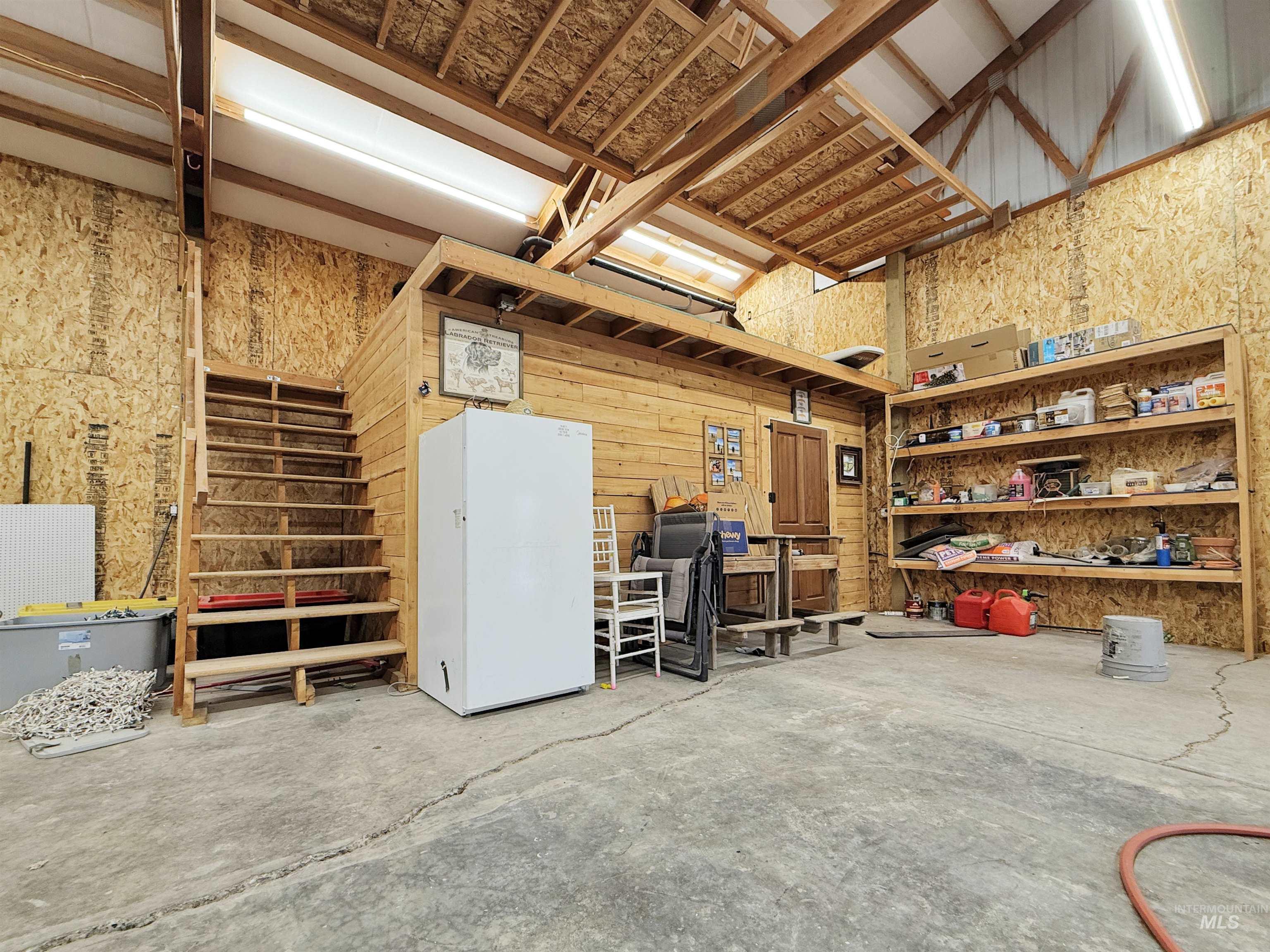 Garage with freestanding refrigerator and wood walls