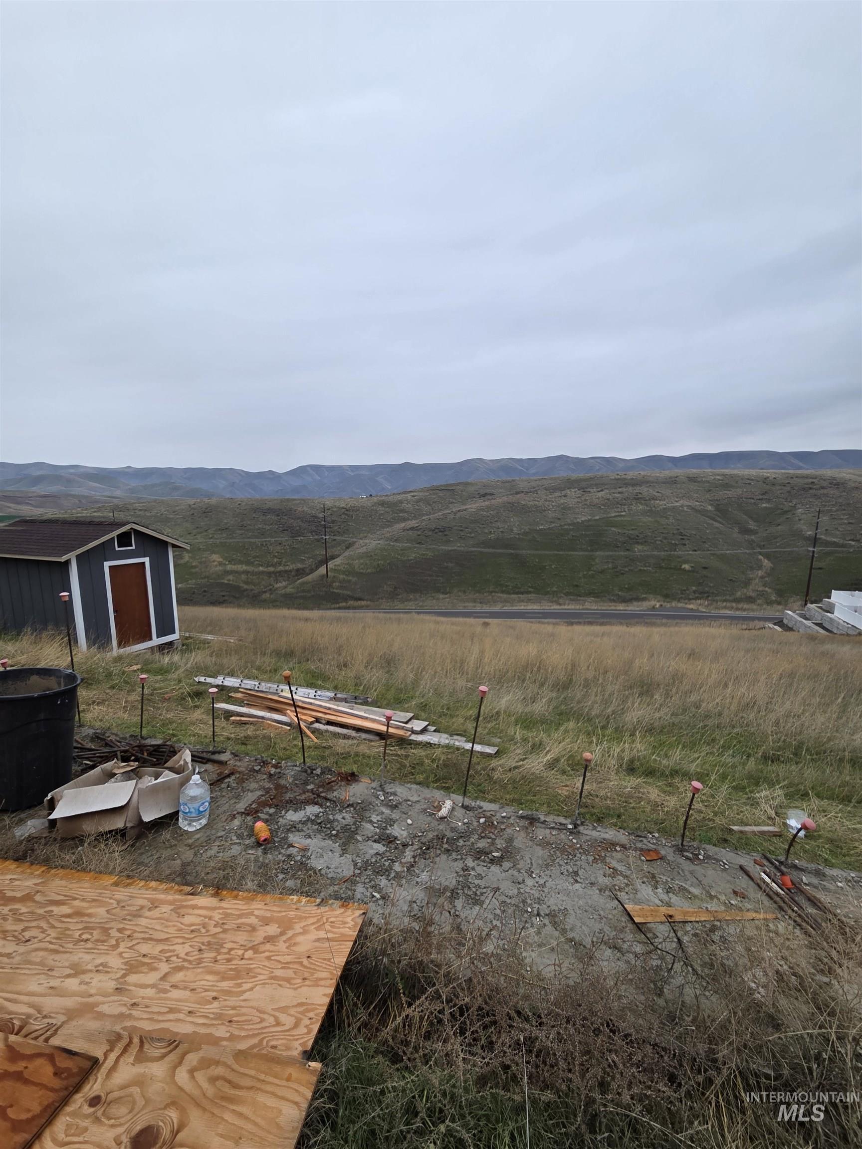 View of yard featuring a mountain view, a view of rural / pastoral area, and a storage shed