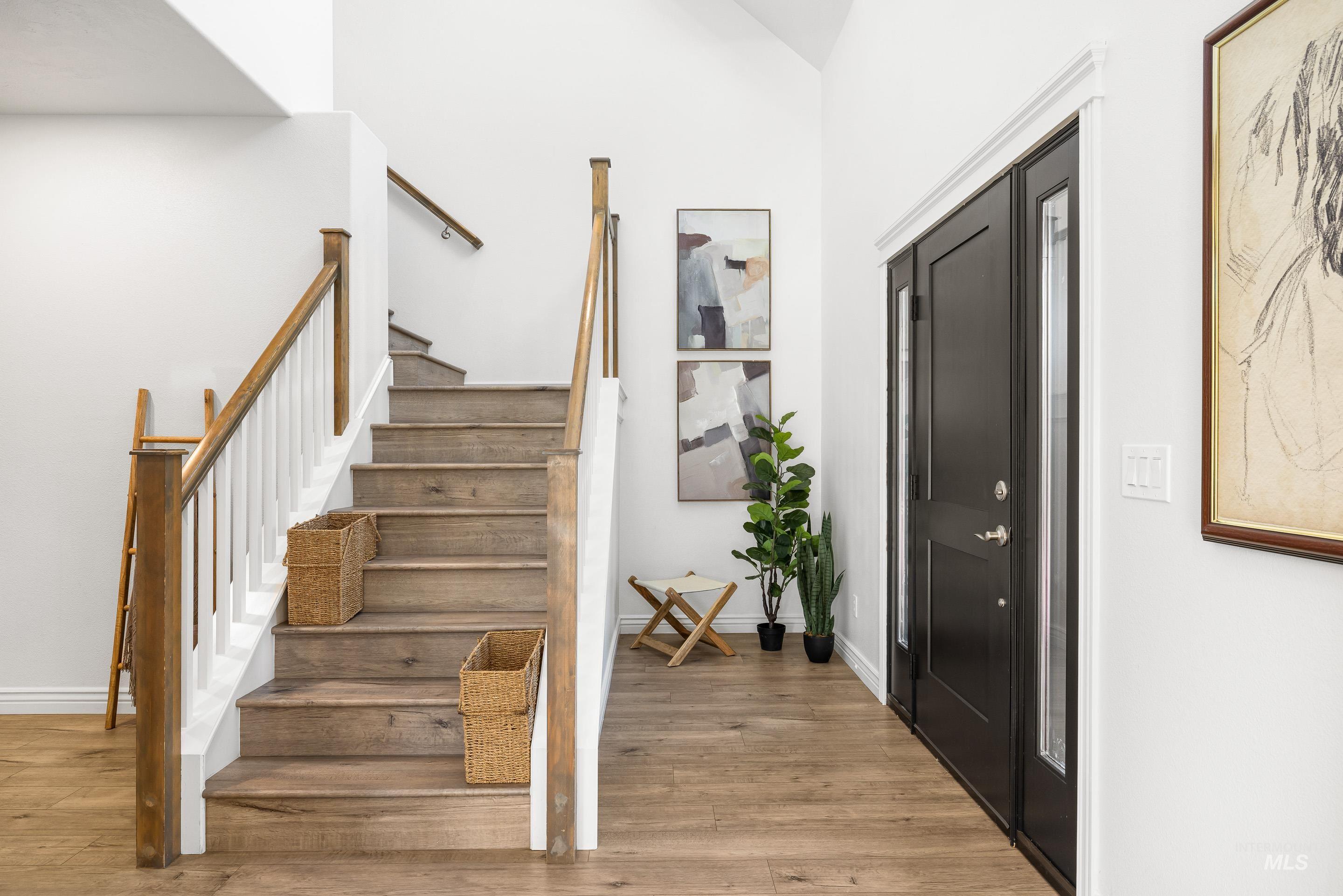 Stairway with wood finished floors and baseboards