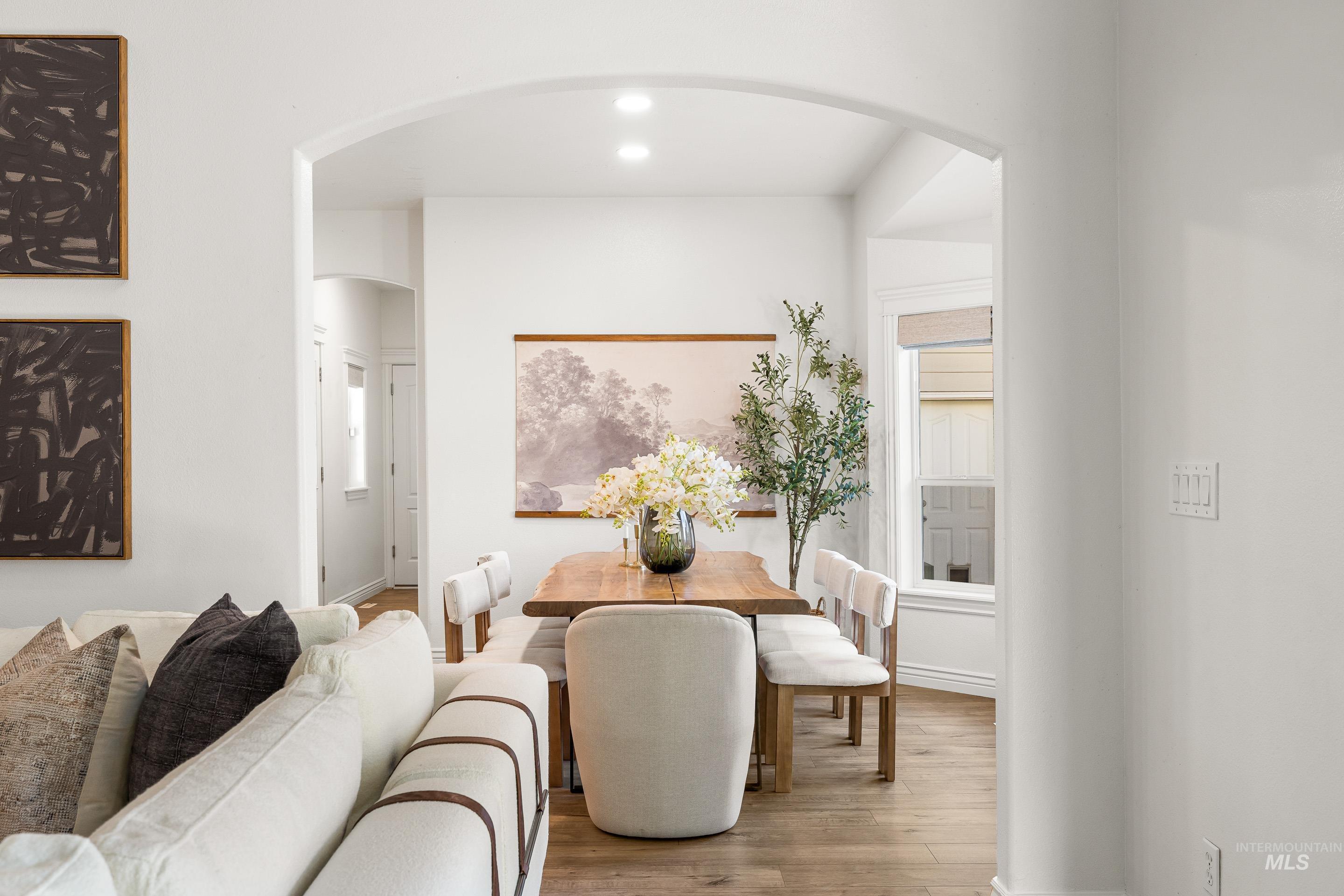 Dining room featuring arched walkways, wood finished floors, and recessed lighting