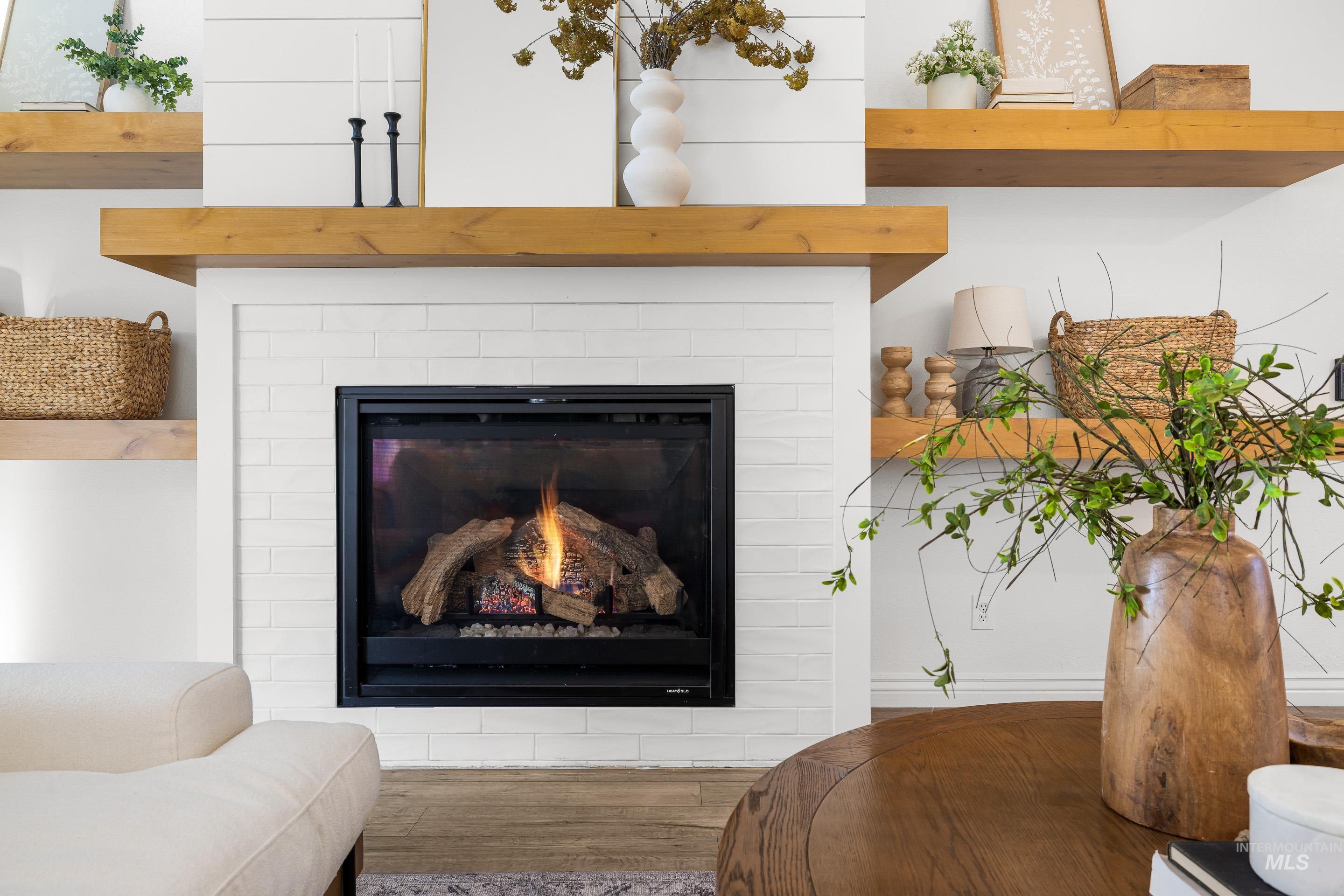 Detailed view of wood finished floors and a glass covered fireplace