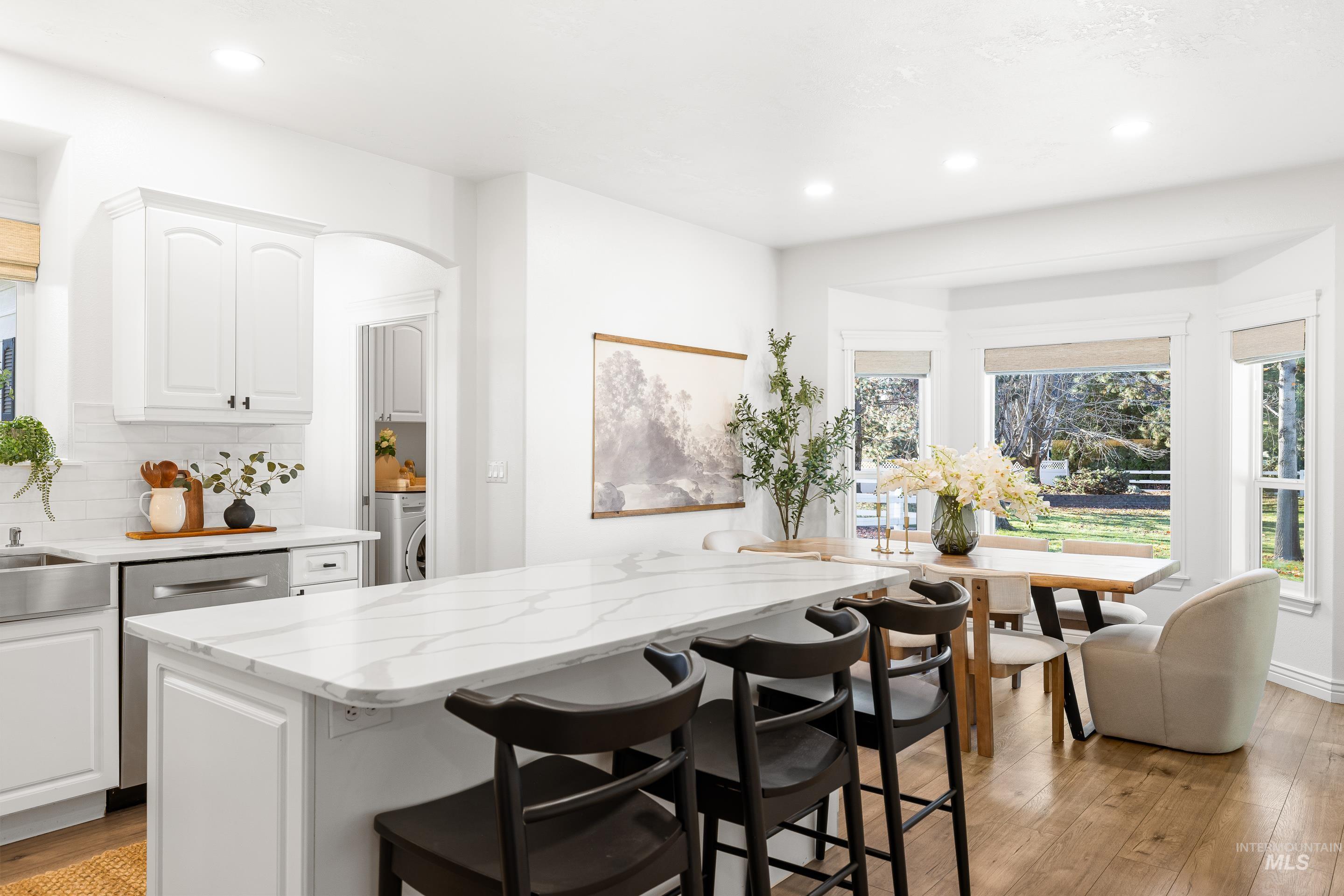 Kitchen featuring light stone counters, white cabinetry, light wood-style floors, and recessed lighting