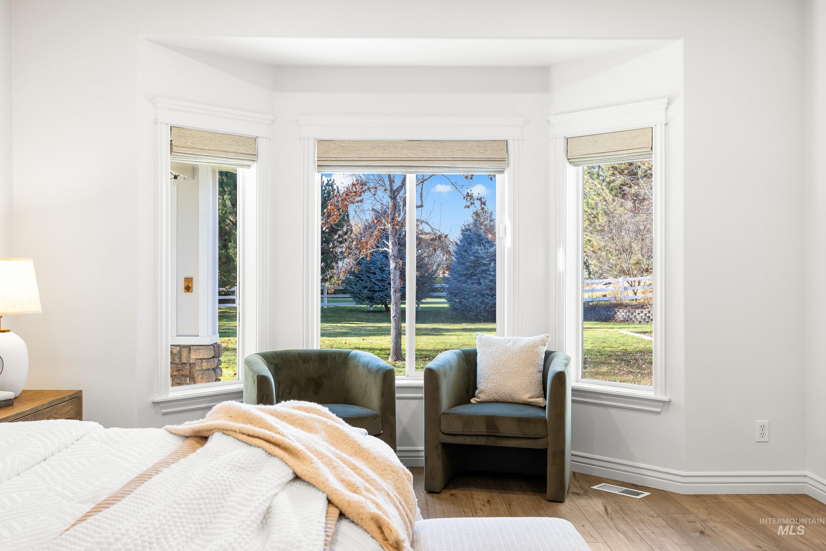 Bedroom with hardwood / wood-style floors and baseboards