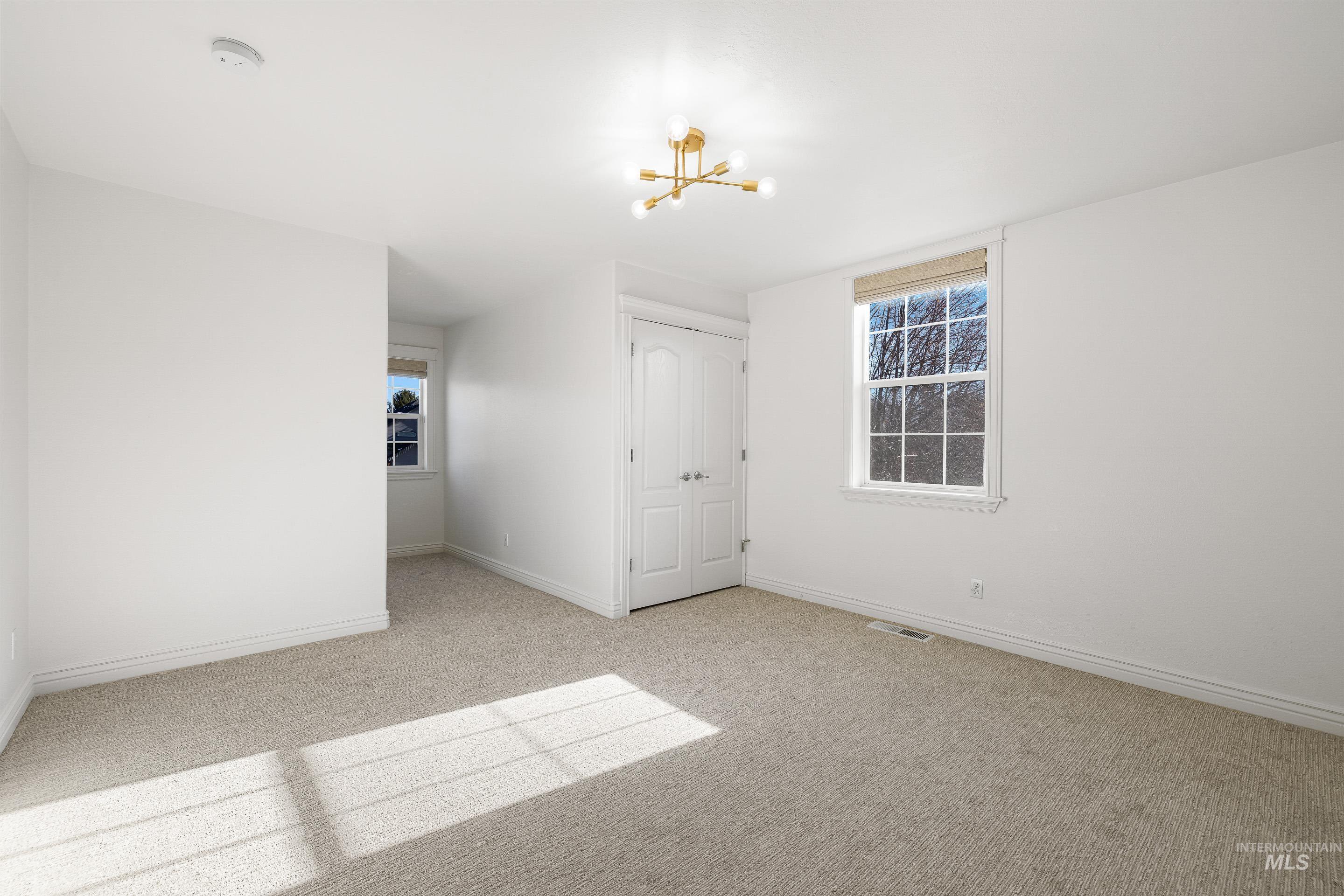 Empty room with a chandelier and light carpet