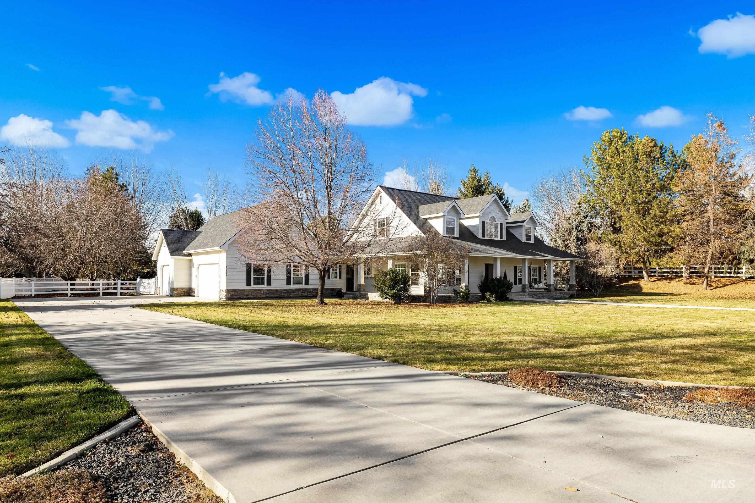 New england style home with a porch, driveway, and stone siding