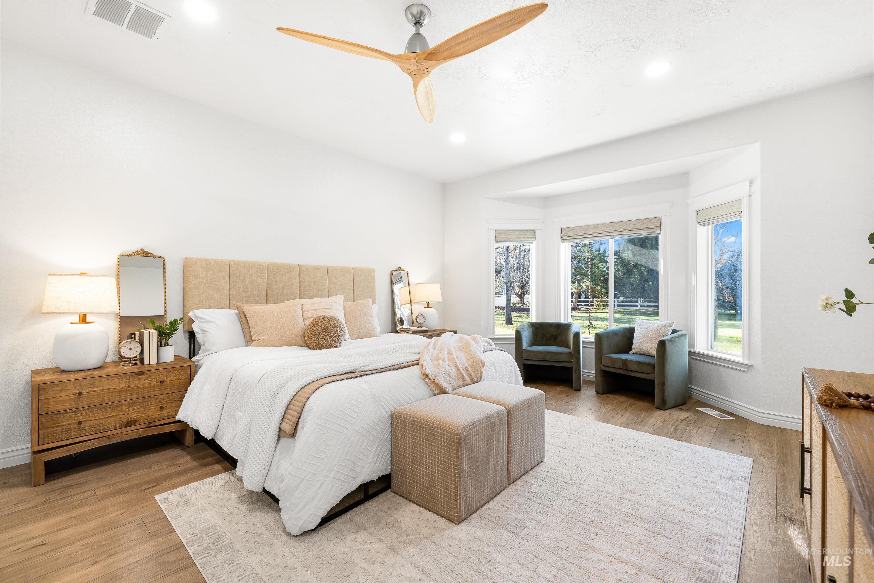 Bedroom with light wood-style floors, a ceiling fan, and recessed lighting