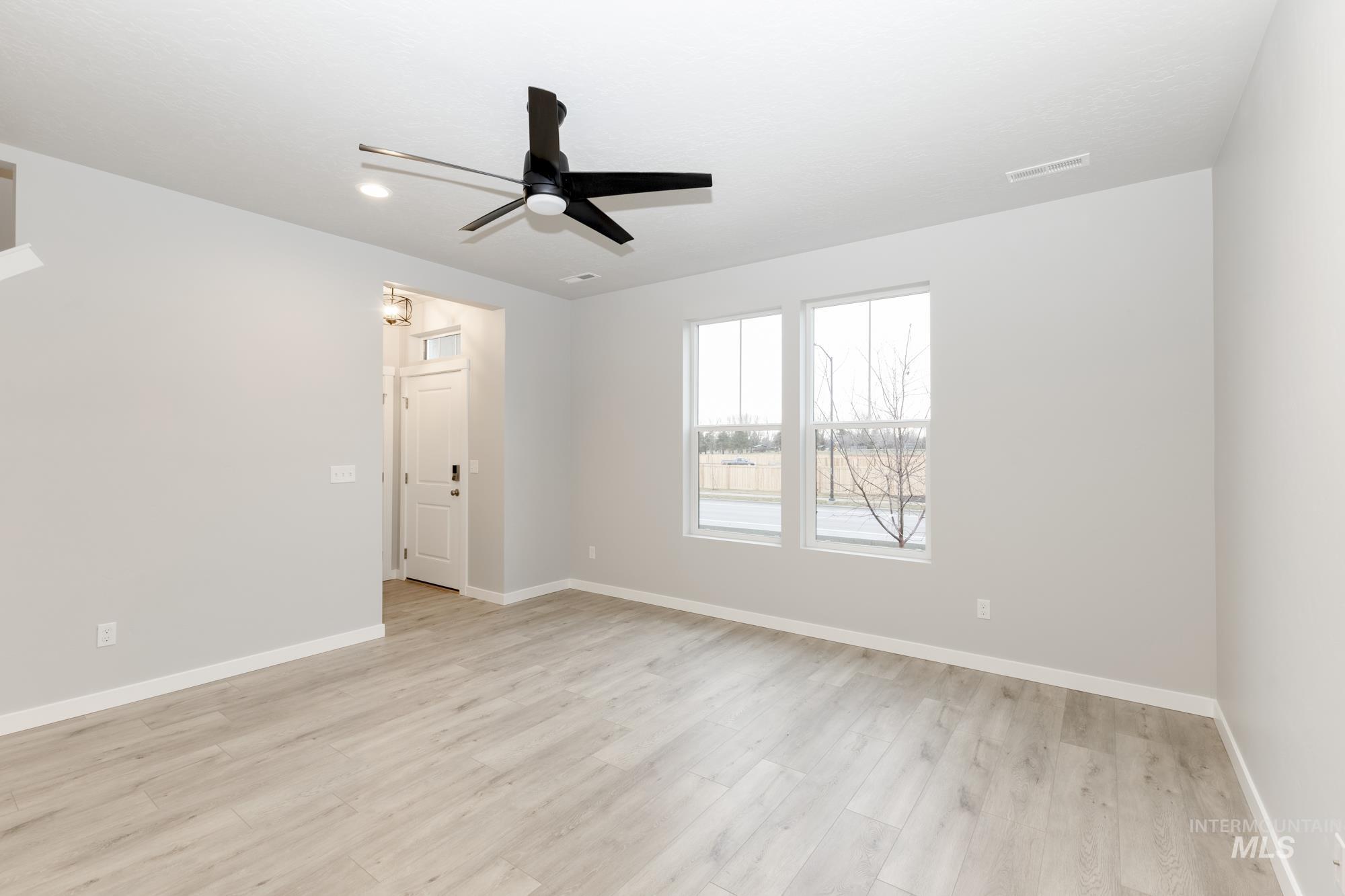 Unfurnished room with light wood-style floors and a ceiling fan