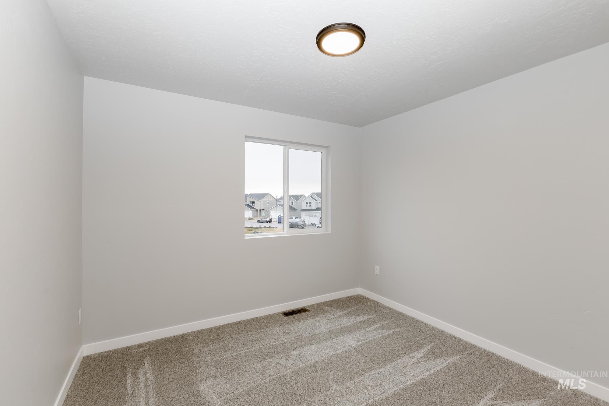Spare room with baseboards and carpet