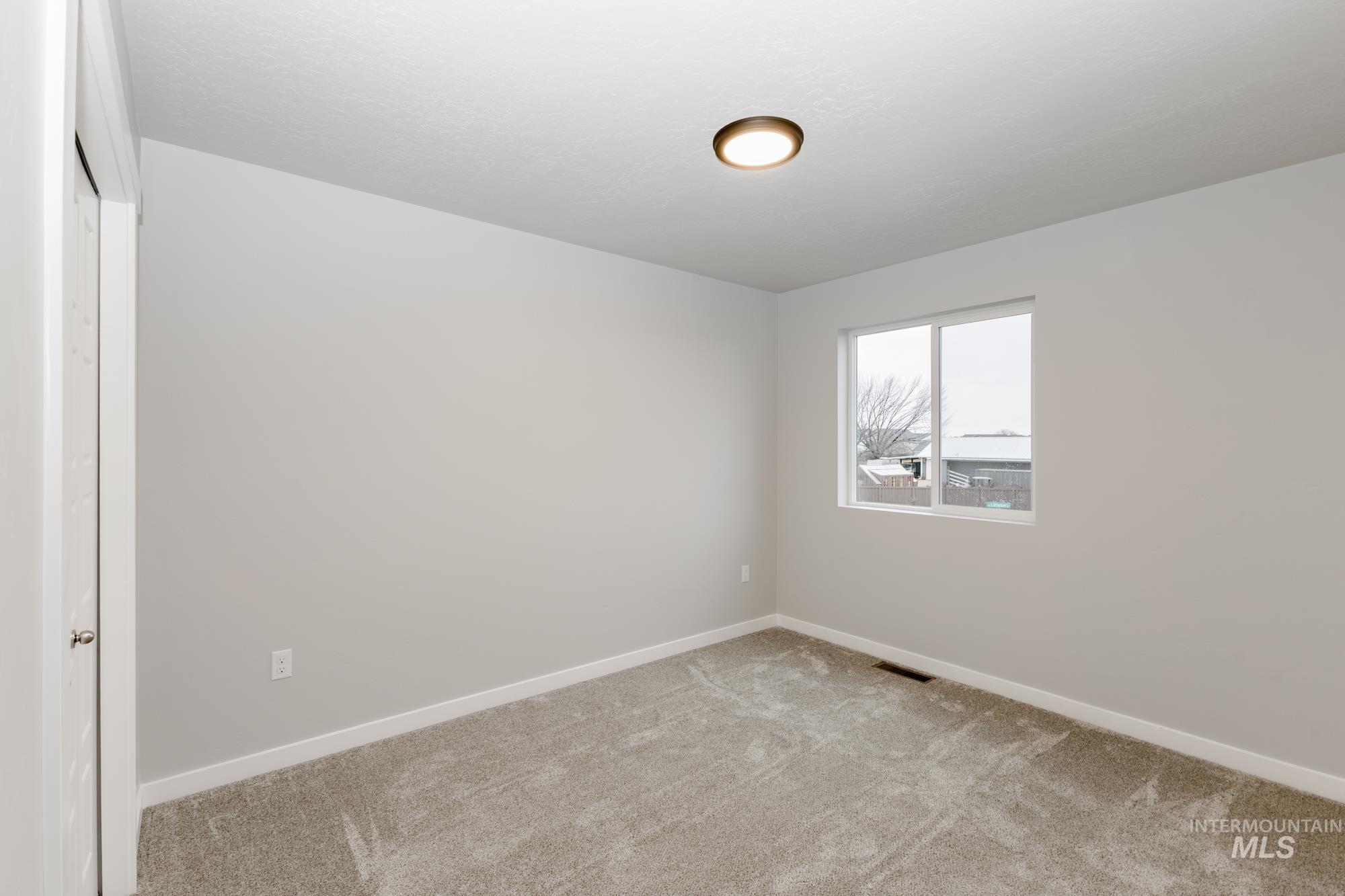 Carpeted spare room with baseboards