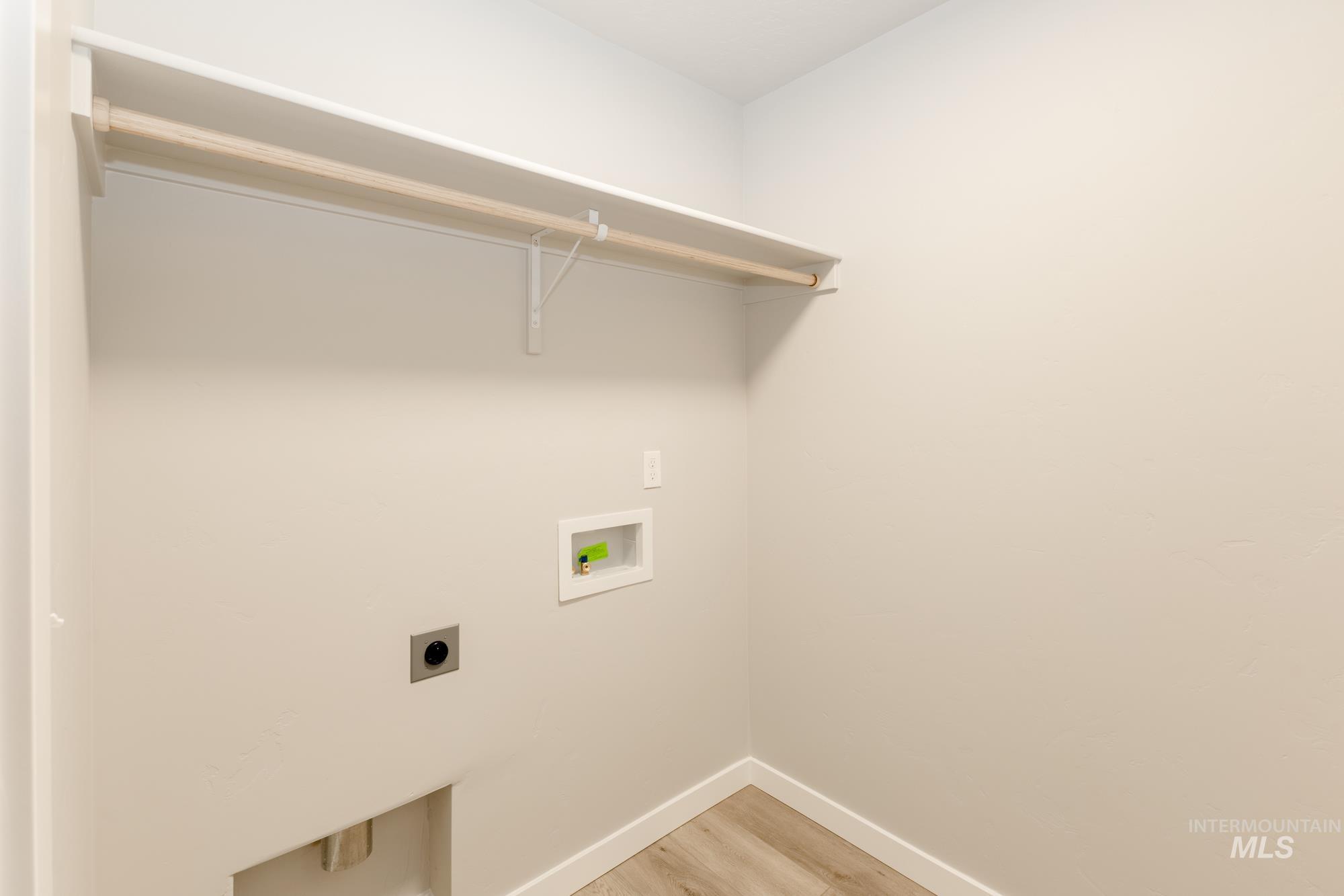 Laundry room with light wood-style floors, electric dryer hookup, and hookup for a washing machine