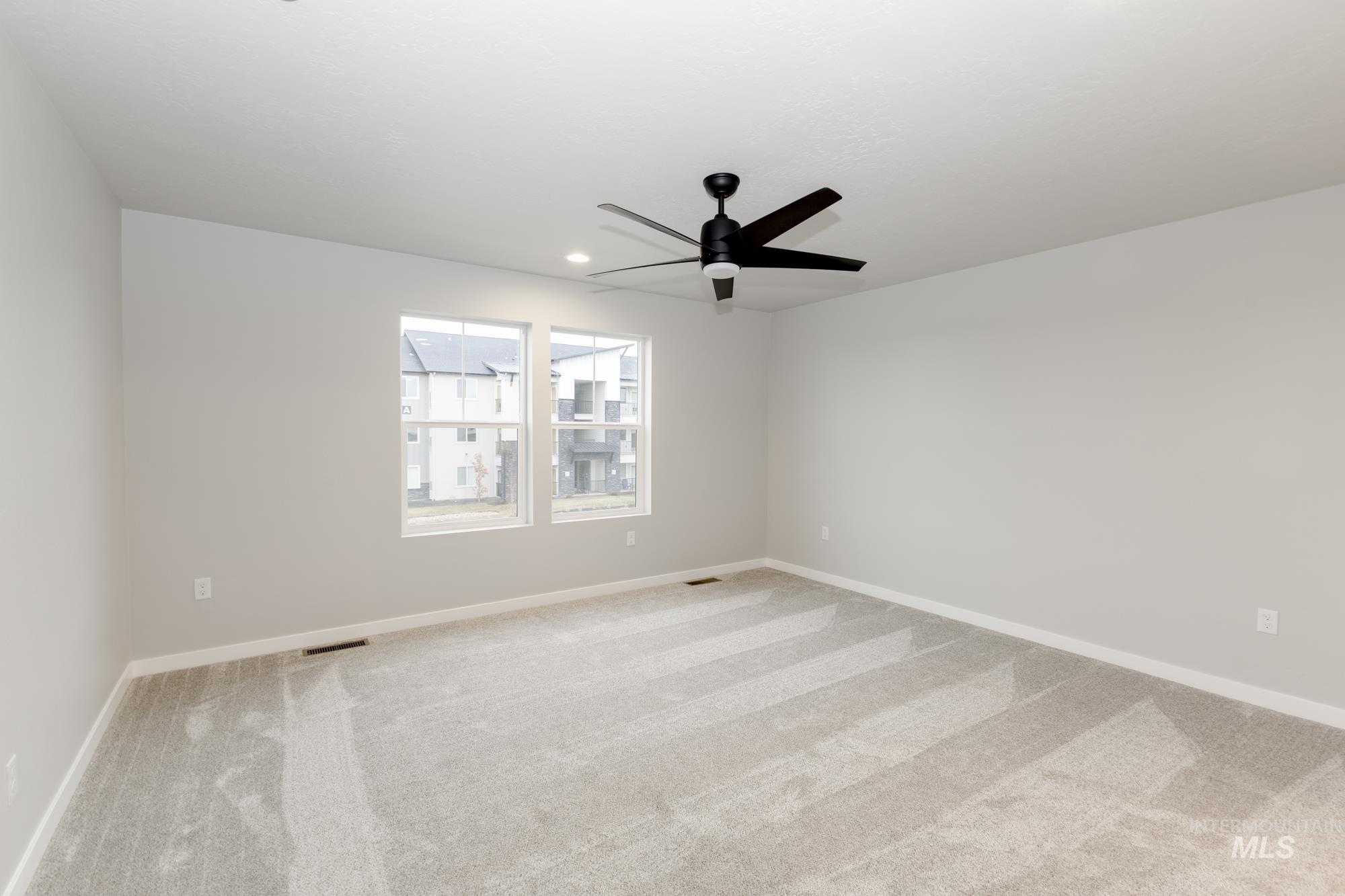 Empty room featuring light colored carpet, a ceiling fan, and recessed lighting