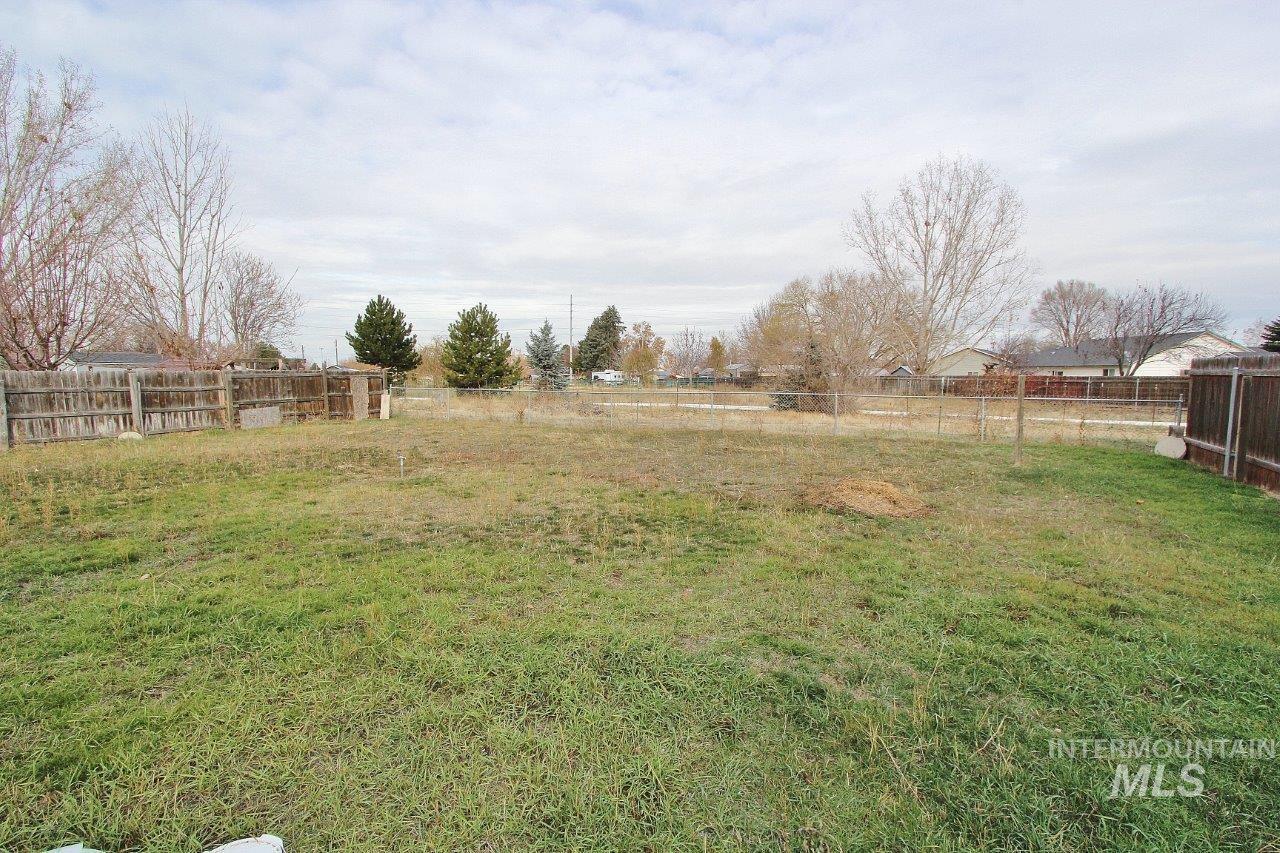 Fenced backyard featuring a view of countryside