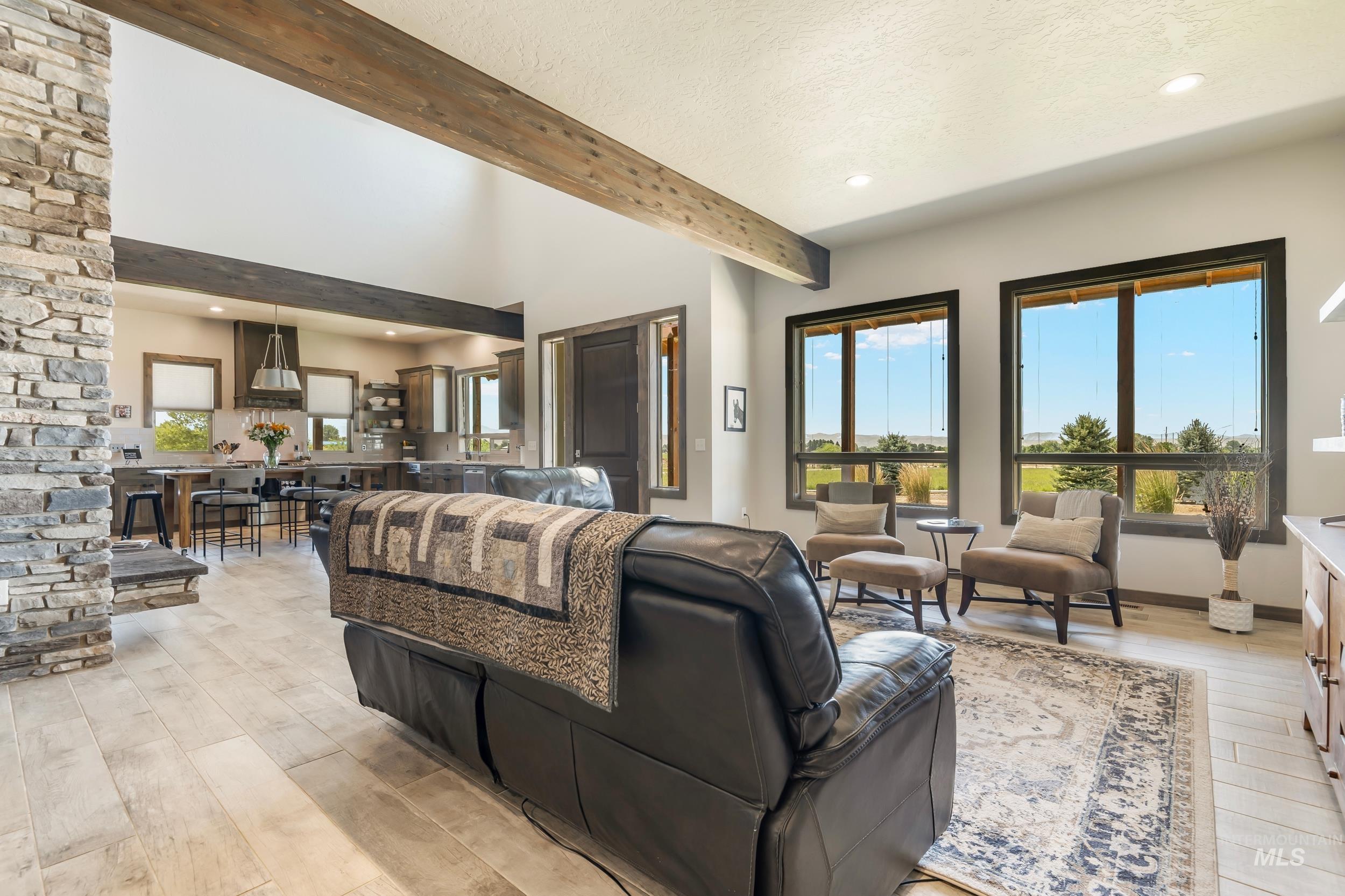 Living area with beam ceiling, light wood-style flooring, recessed lighting, and a textured ceiling