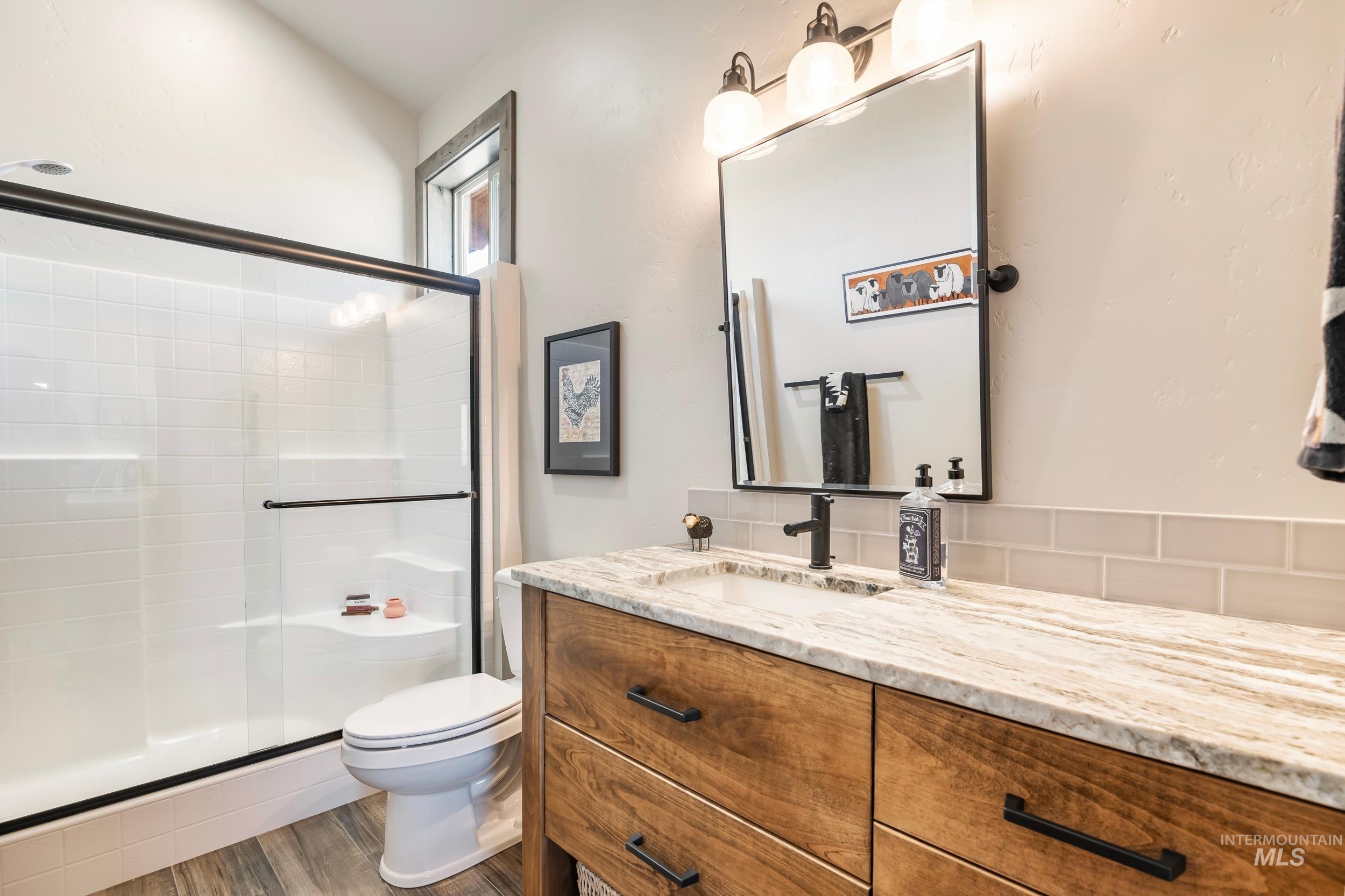 Bathroom featuring vanity, a shower stall, and wood finished floors
