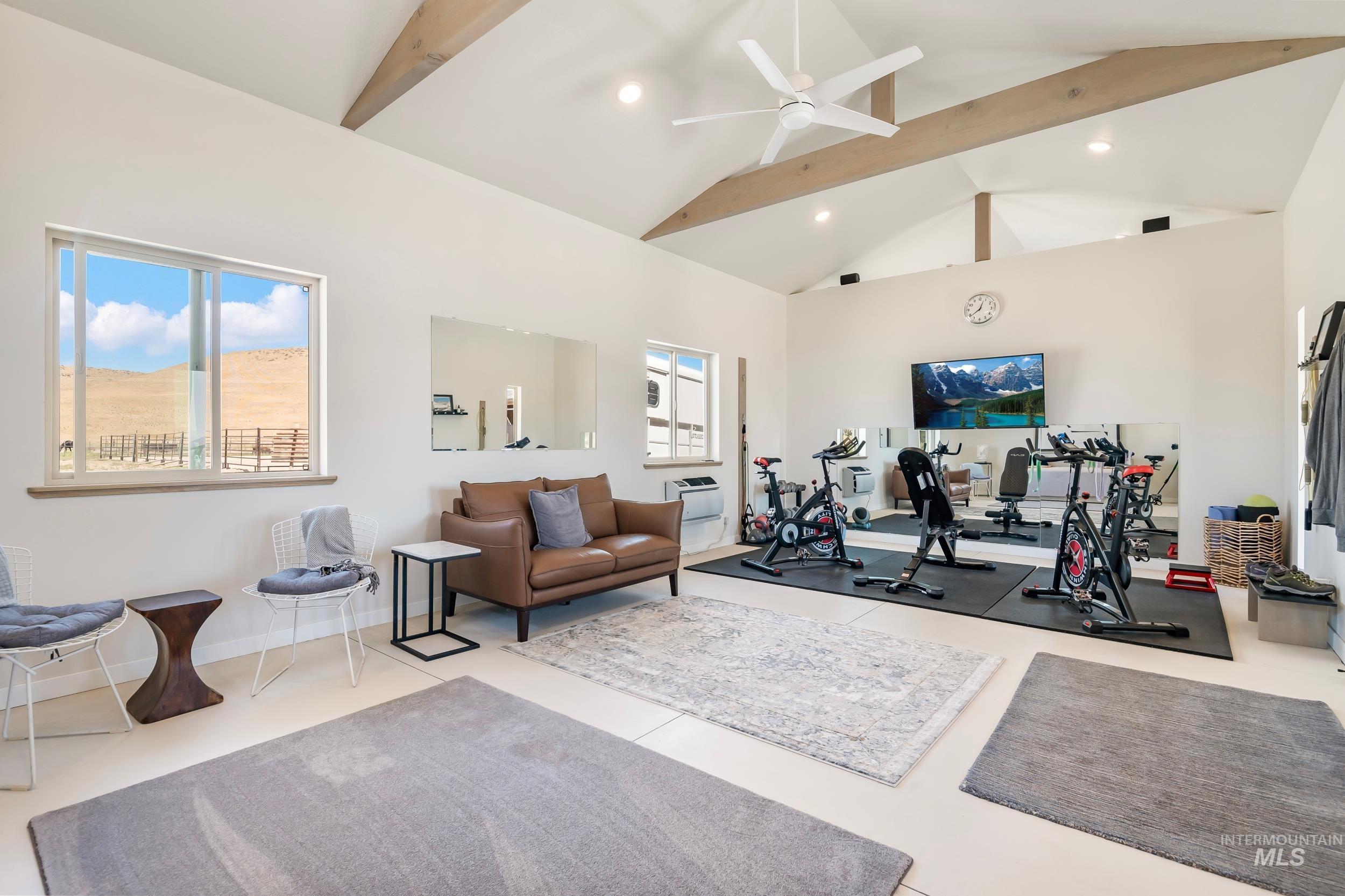 Exercise room with plenty of natural light, high vaulted ceiling, a ceiling fan, and recessed lighting