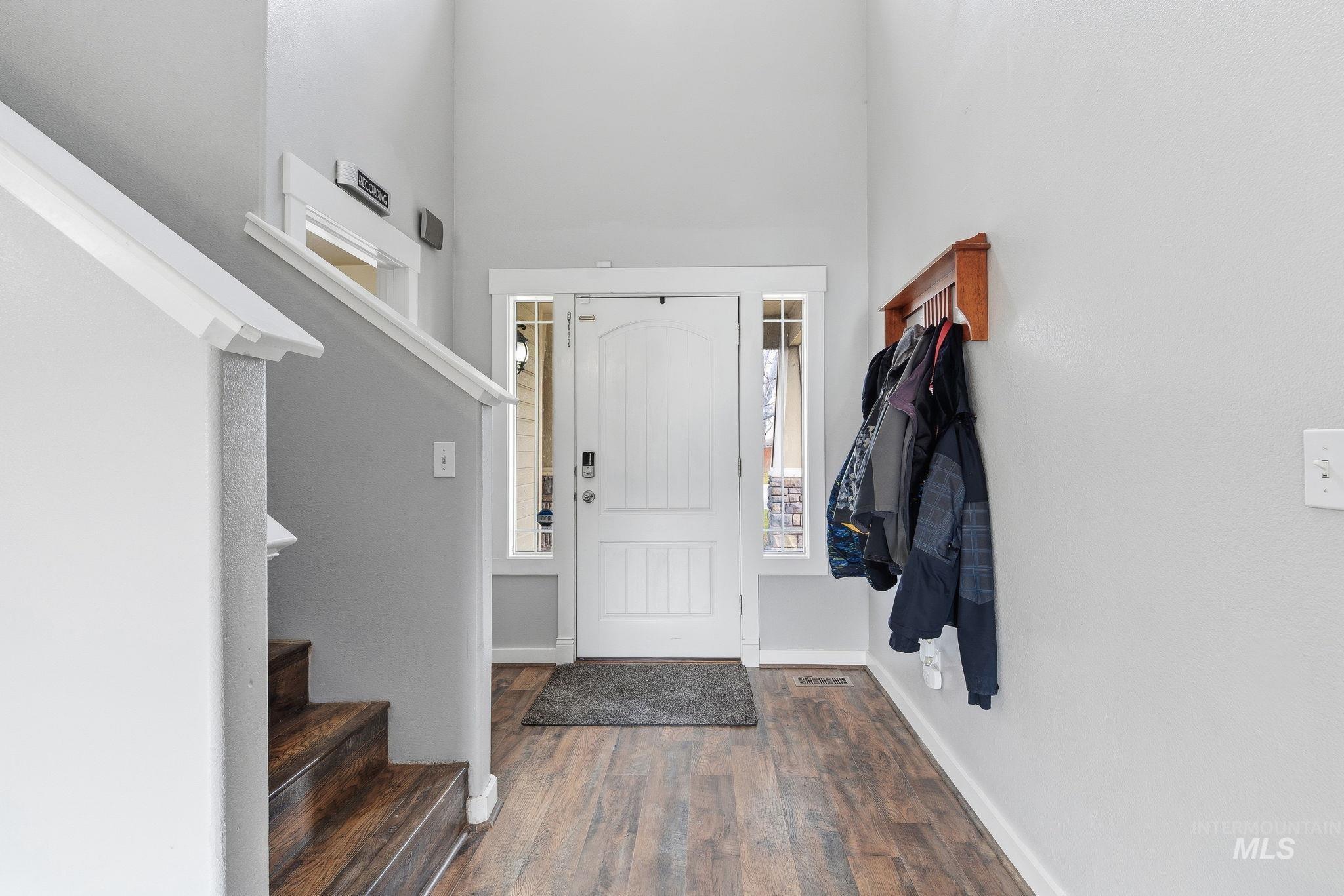 Foyer featuring stairs and dark wood-type flooring