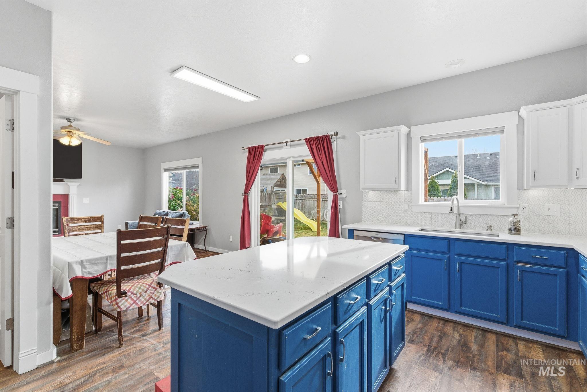 Kitchen featuring blue cabinetry, a center island, tasteful backsplash, light stone counters, and recessed lighting