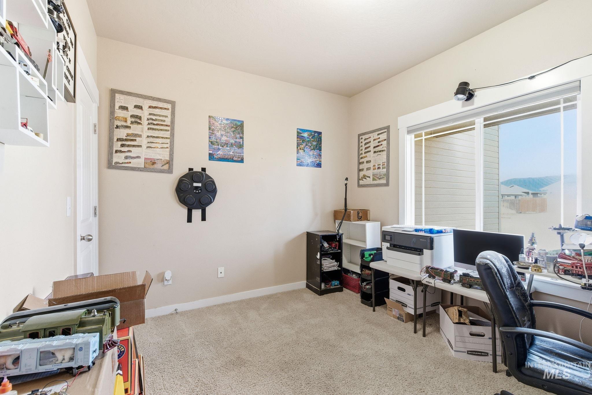 Office area featuring light carpet and baseboards