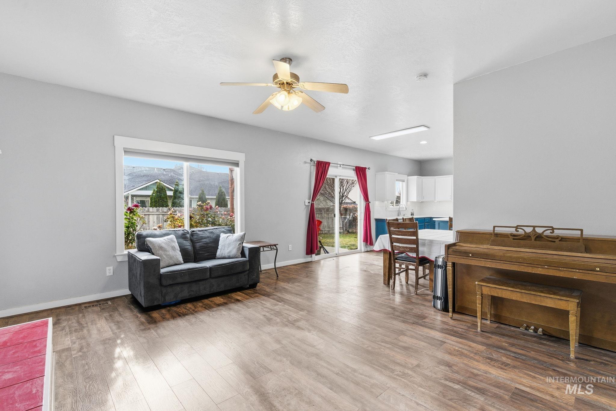 Living room with ceiling fan and light wood finished floors