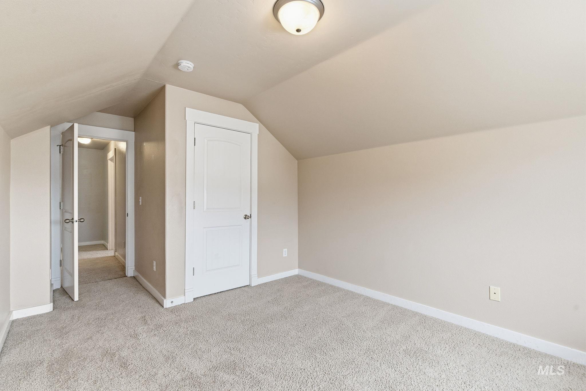 Bonus room with light carpet and lofted ceiling