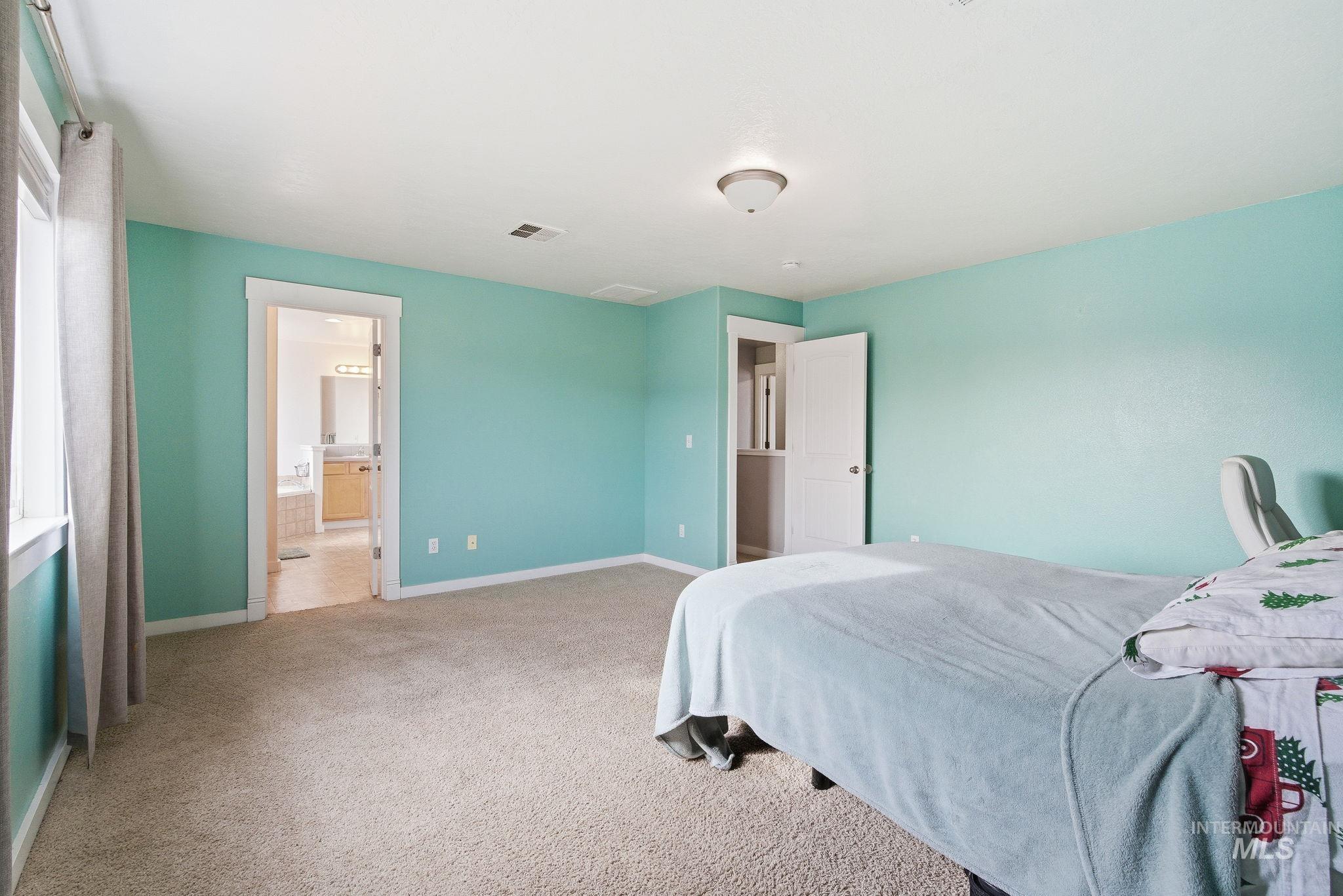 Bedroom featuring light carpet and baseboards