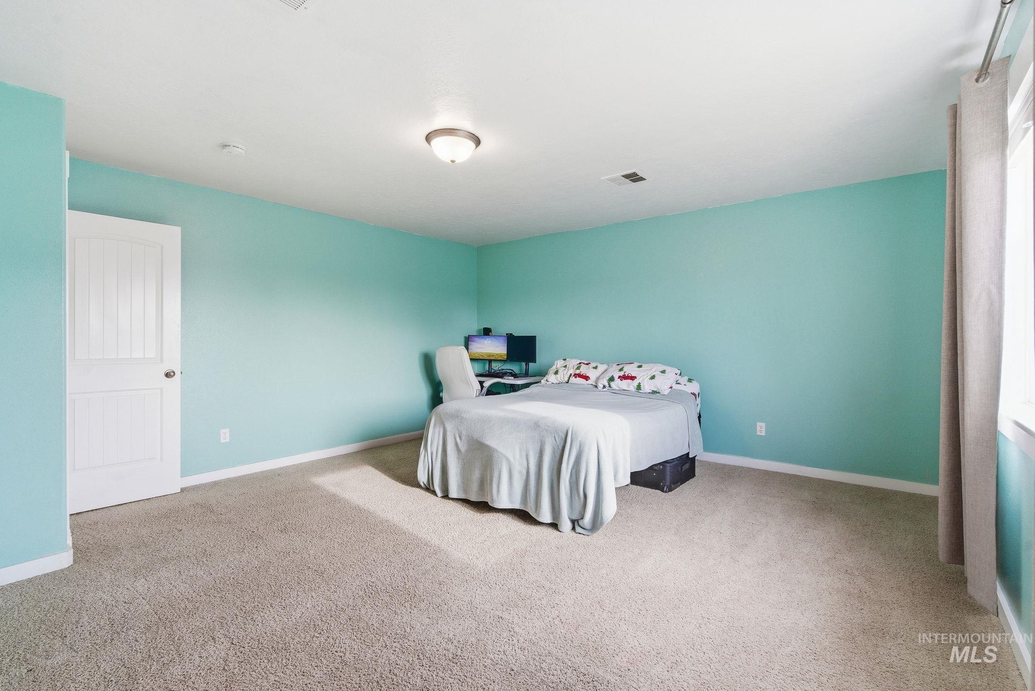 Bedroom featuring light colored carpet and baseboards